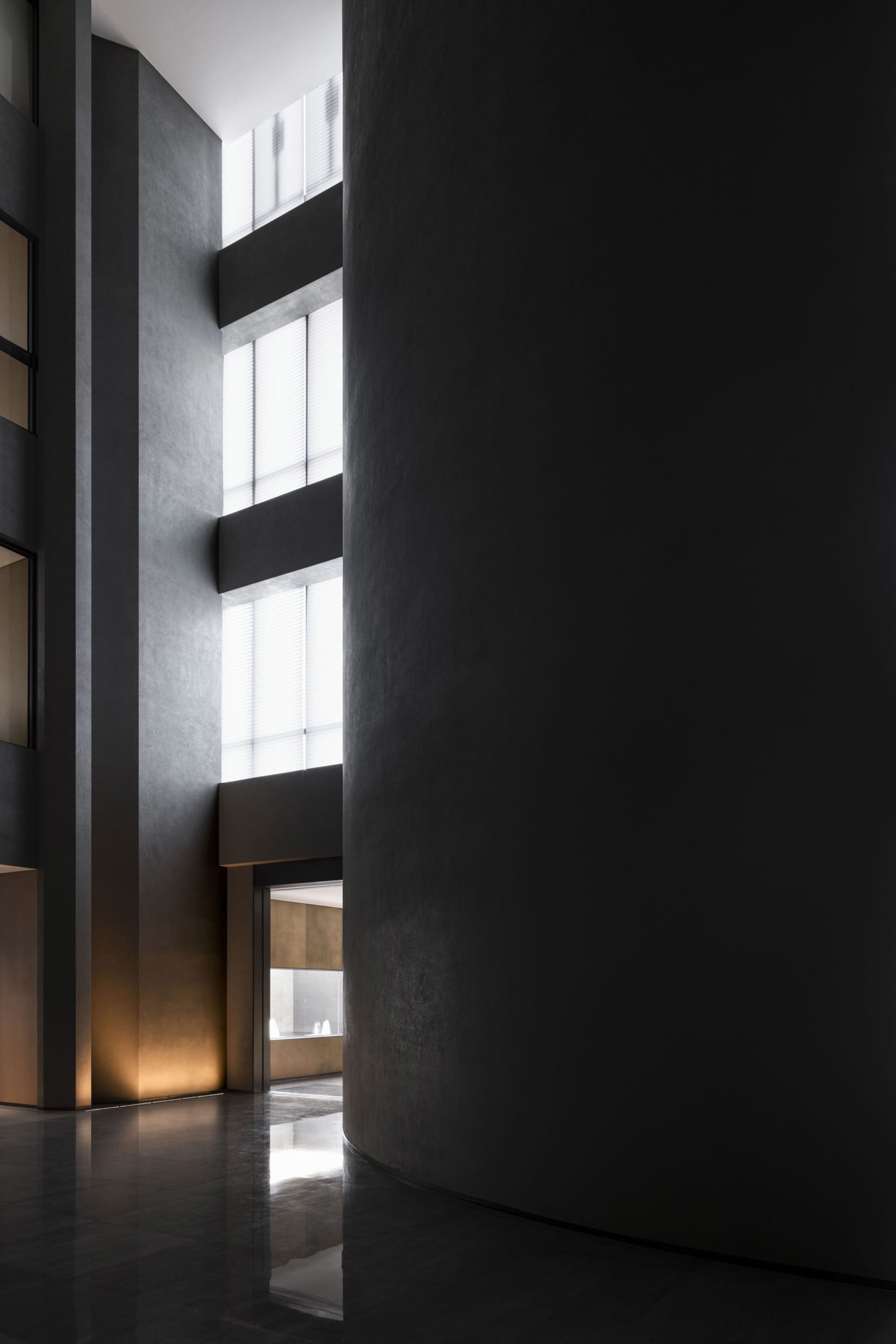 Modern industrial style lobby with dark concrete walls and lighting.