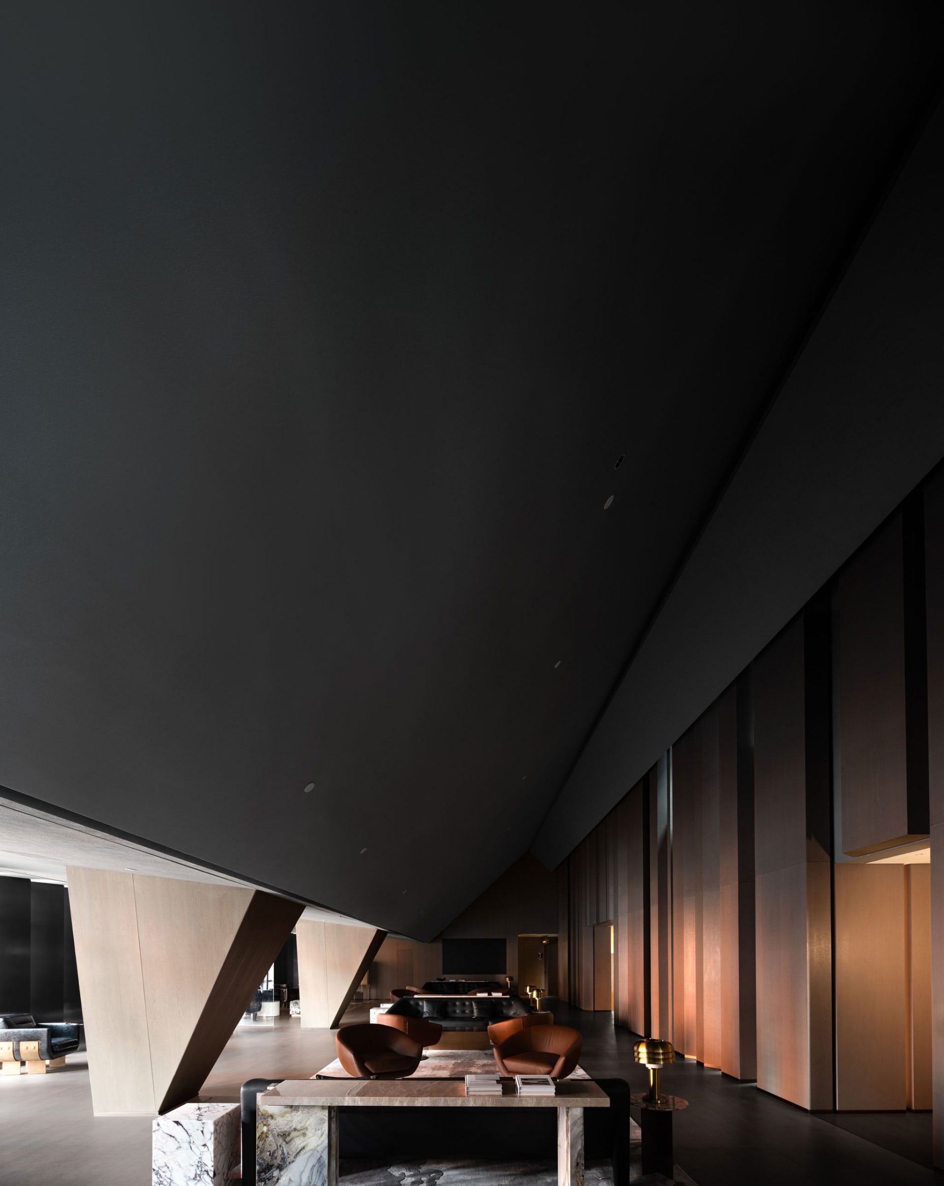 A modern lobby with metallic walls and dark wood accents.