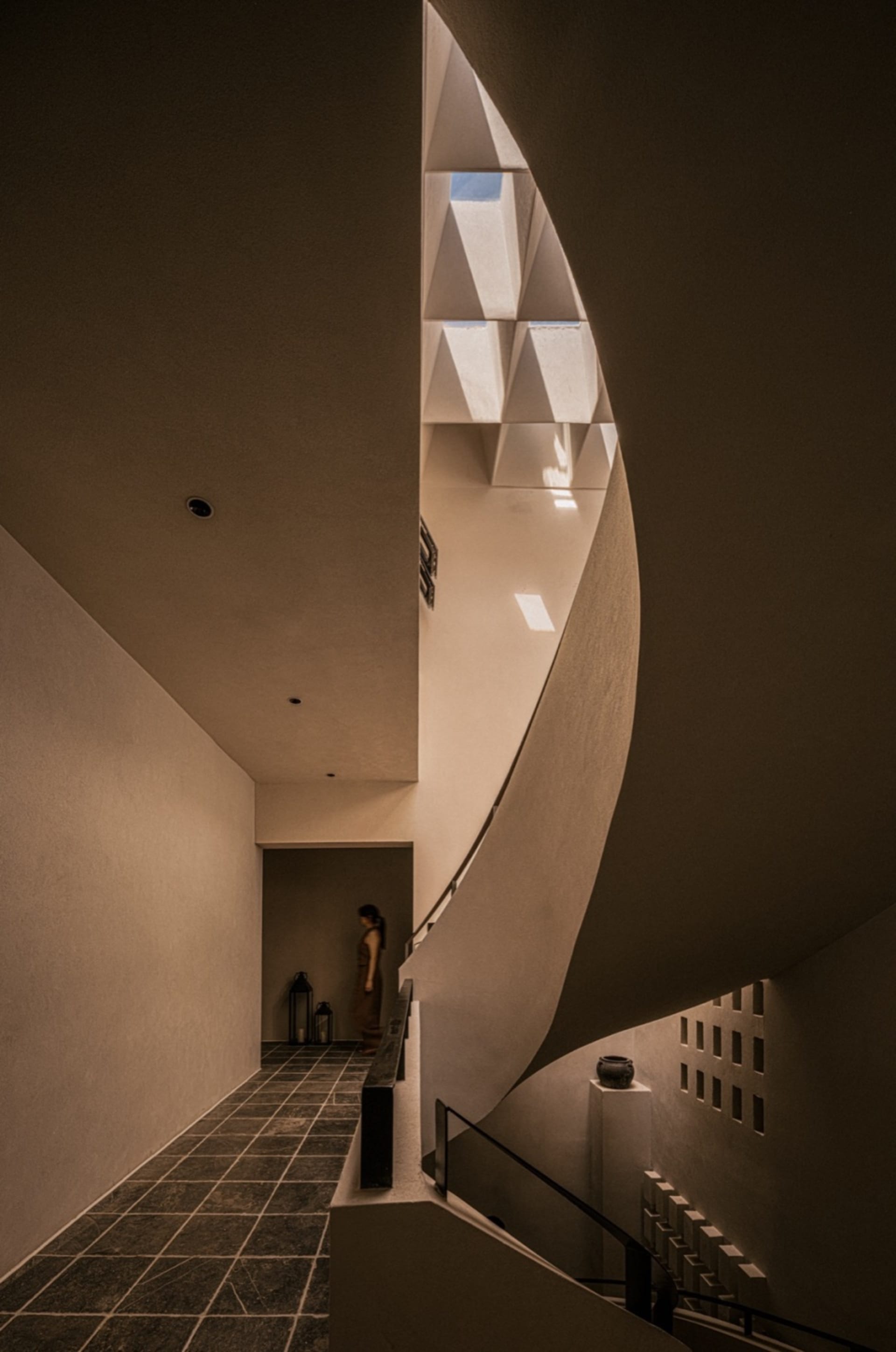 Modern staircase with concrete walls and floors, featuring geometric shapes and industrial design elements.