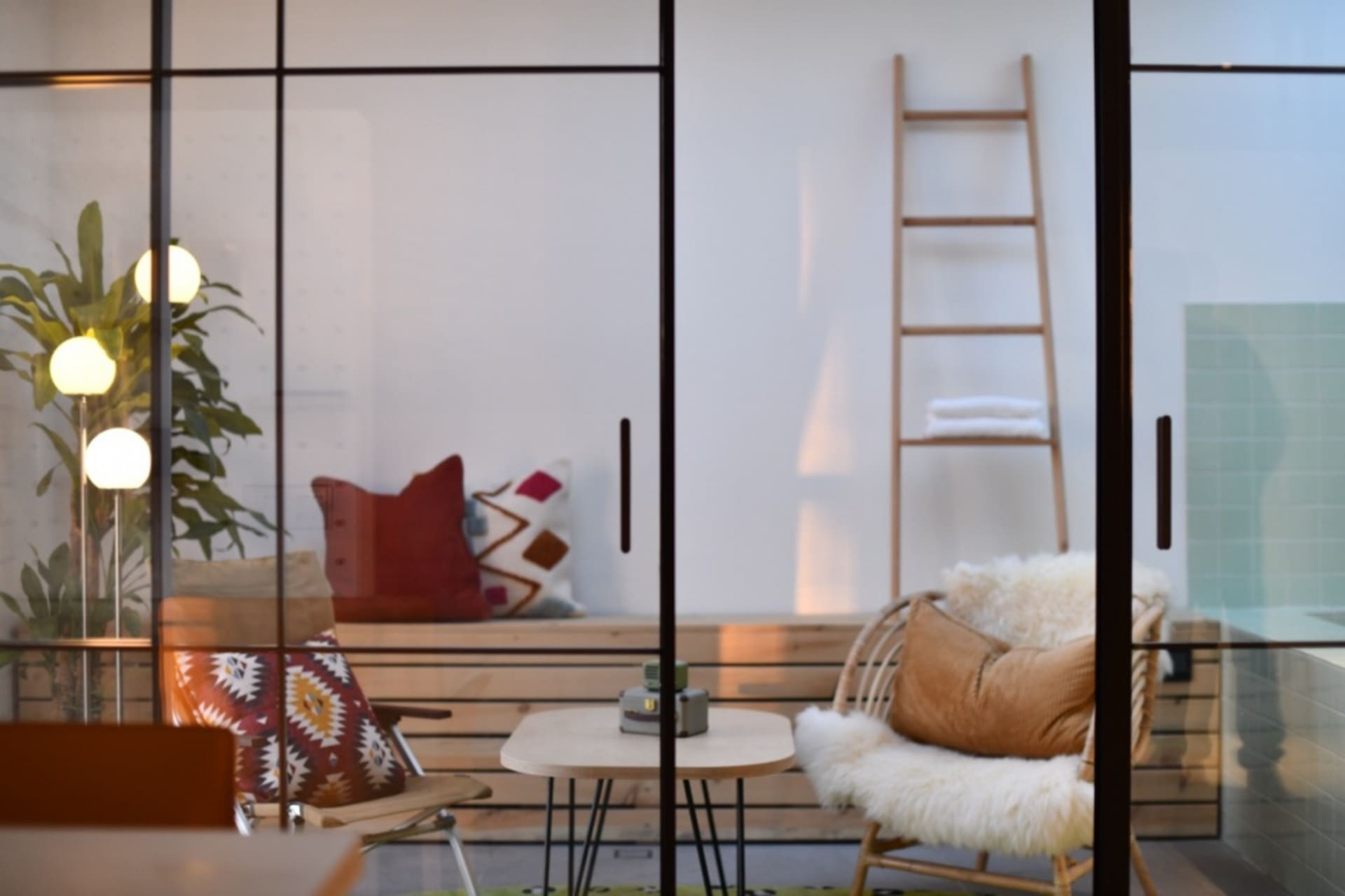 A modern living room featuring wooden furniture, glass window, and fabric cushions.