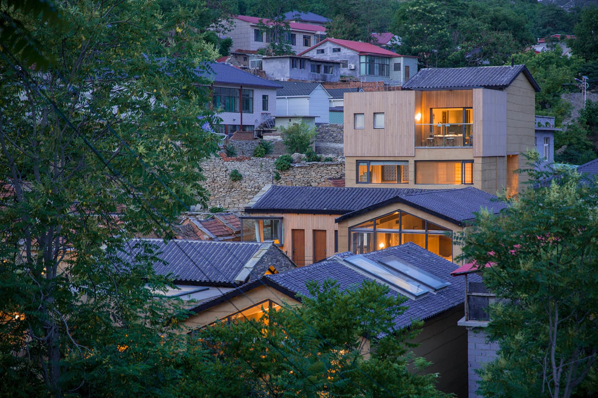 現代多層住宅外觀，窗戶透出溫暖燈光。
