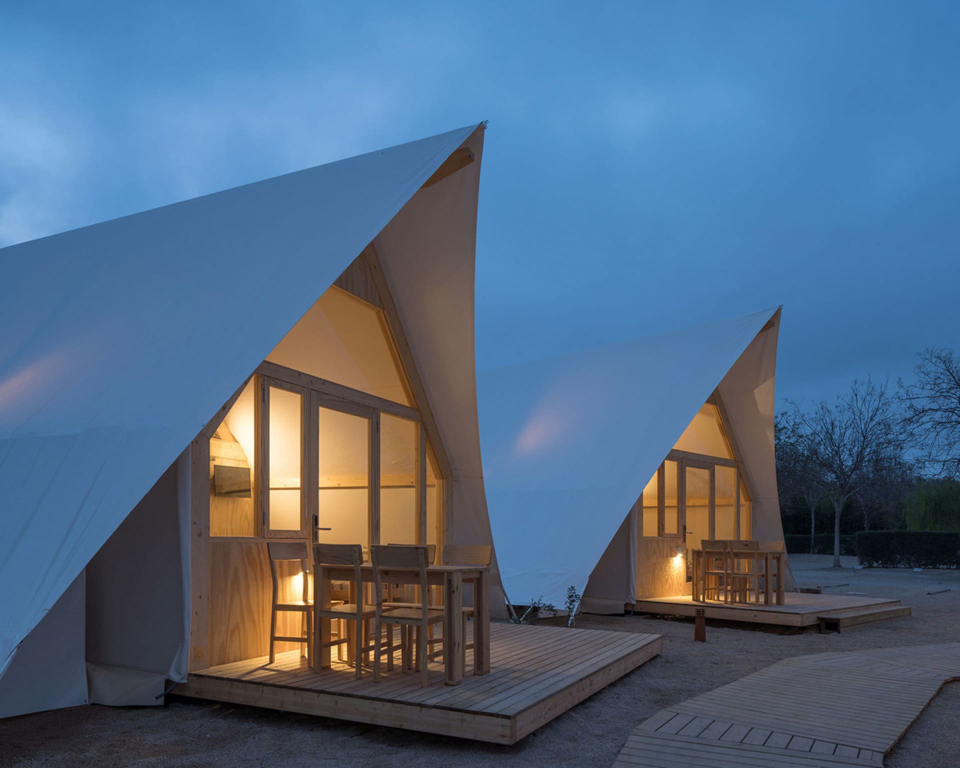Two canvas glamping tents with walls and wooden planks