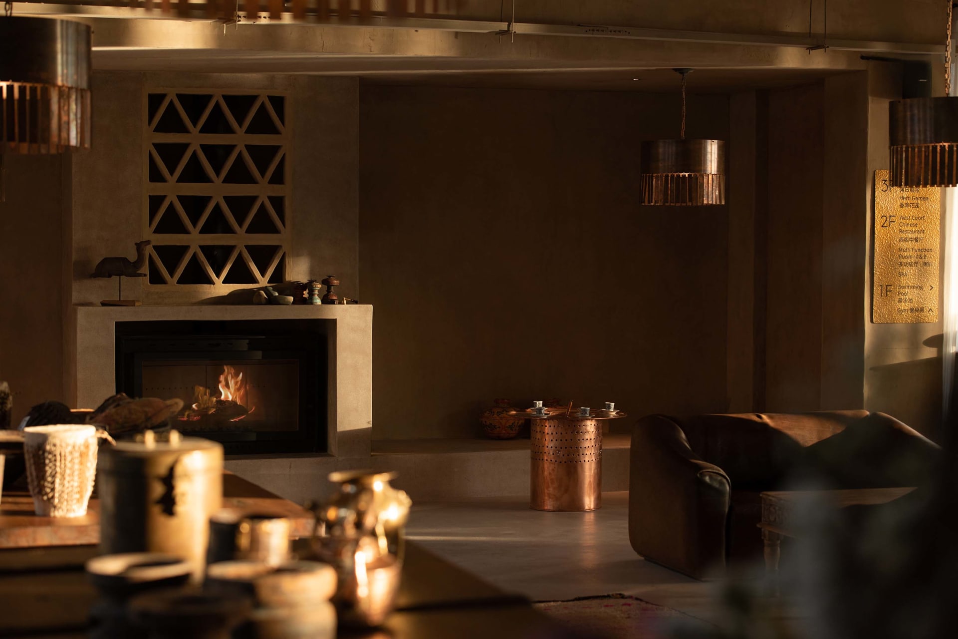 Industrial-style living room featuring a concrete fireplace and warm, ambient lighting.