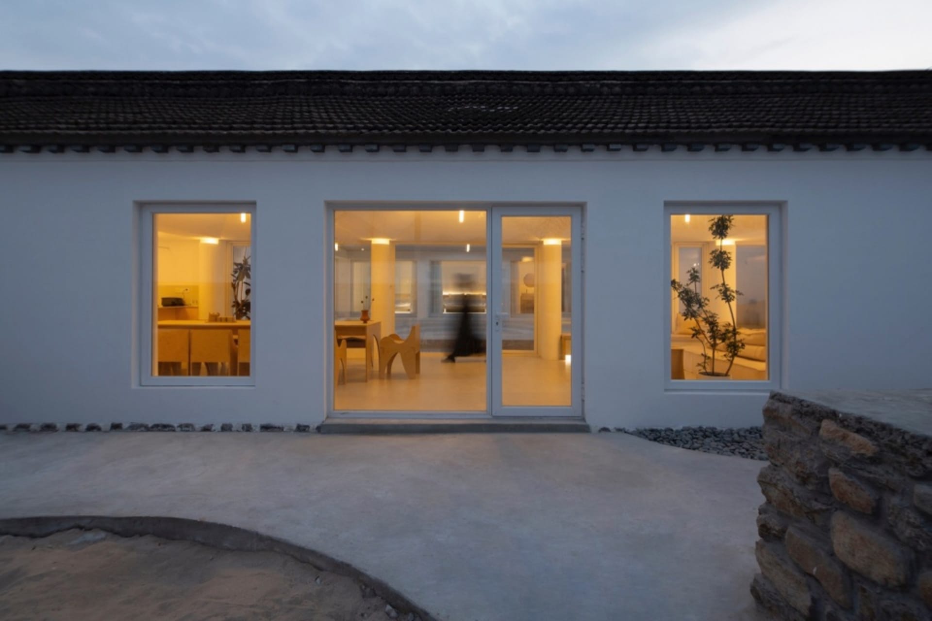 A modern residential entrance with concrete flooring and soft lighting.