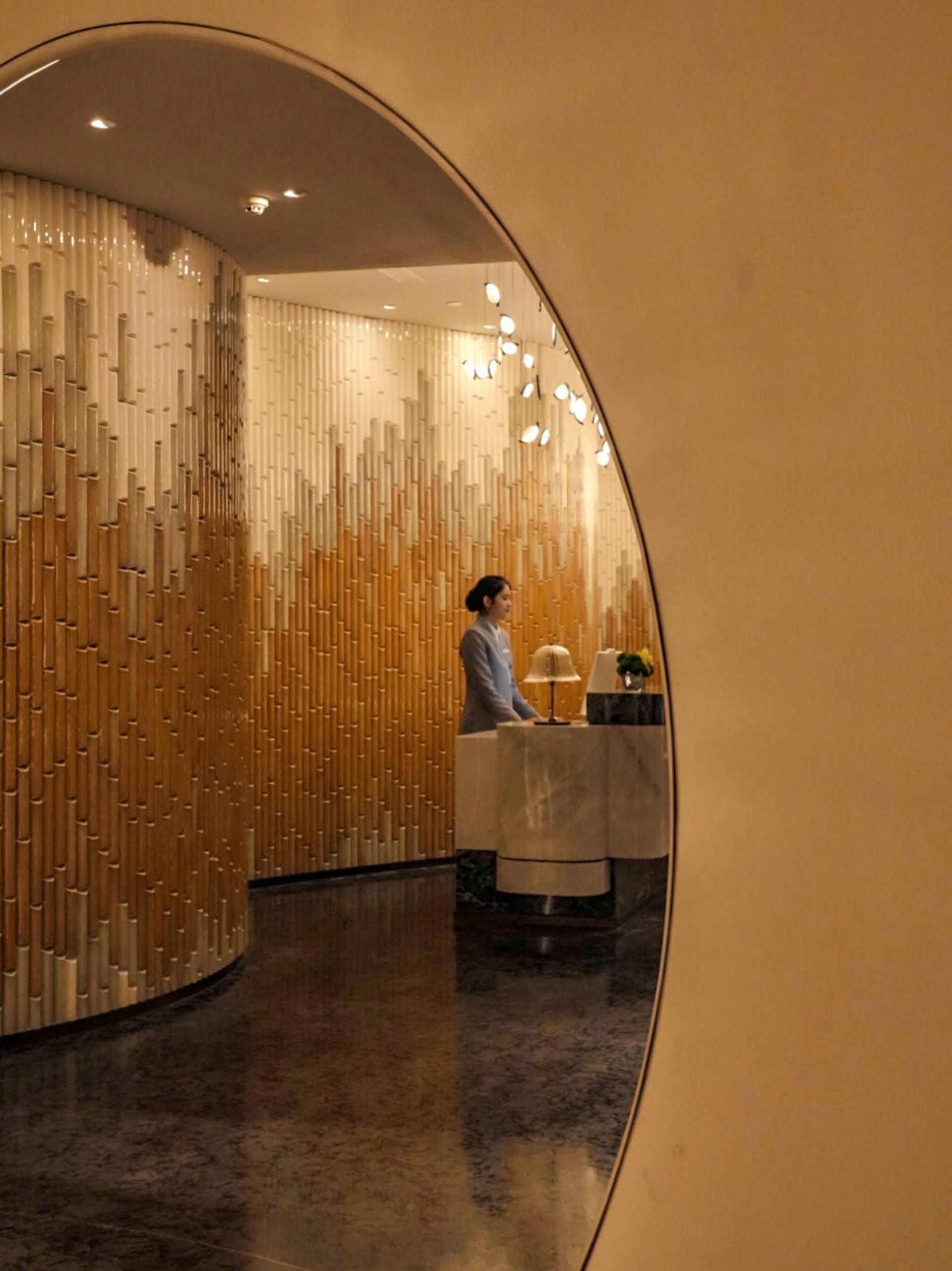 現代酒店大廳，鋪設大理石地磚、木質牆板，並搭配環境照明。