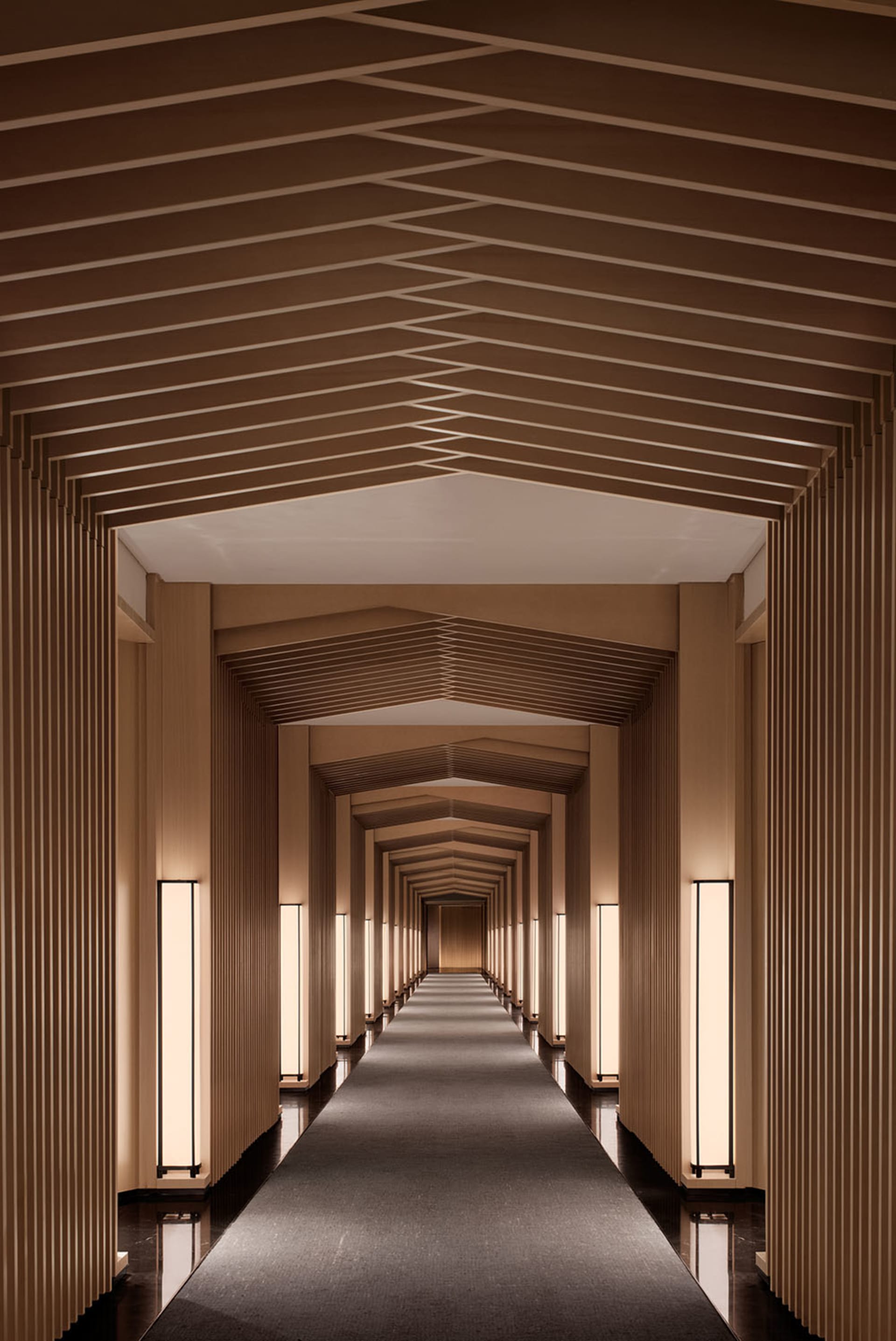 A modern corridor with wooden paneling and a long, straight path.