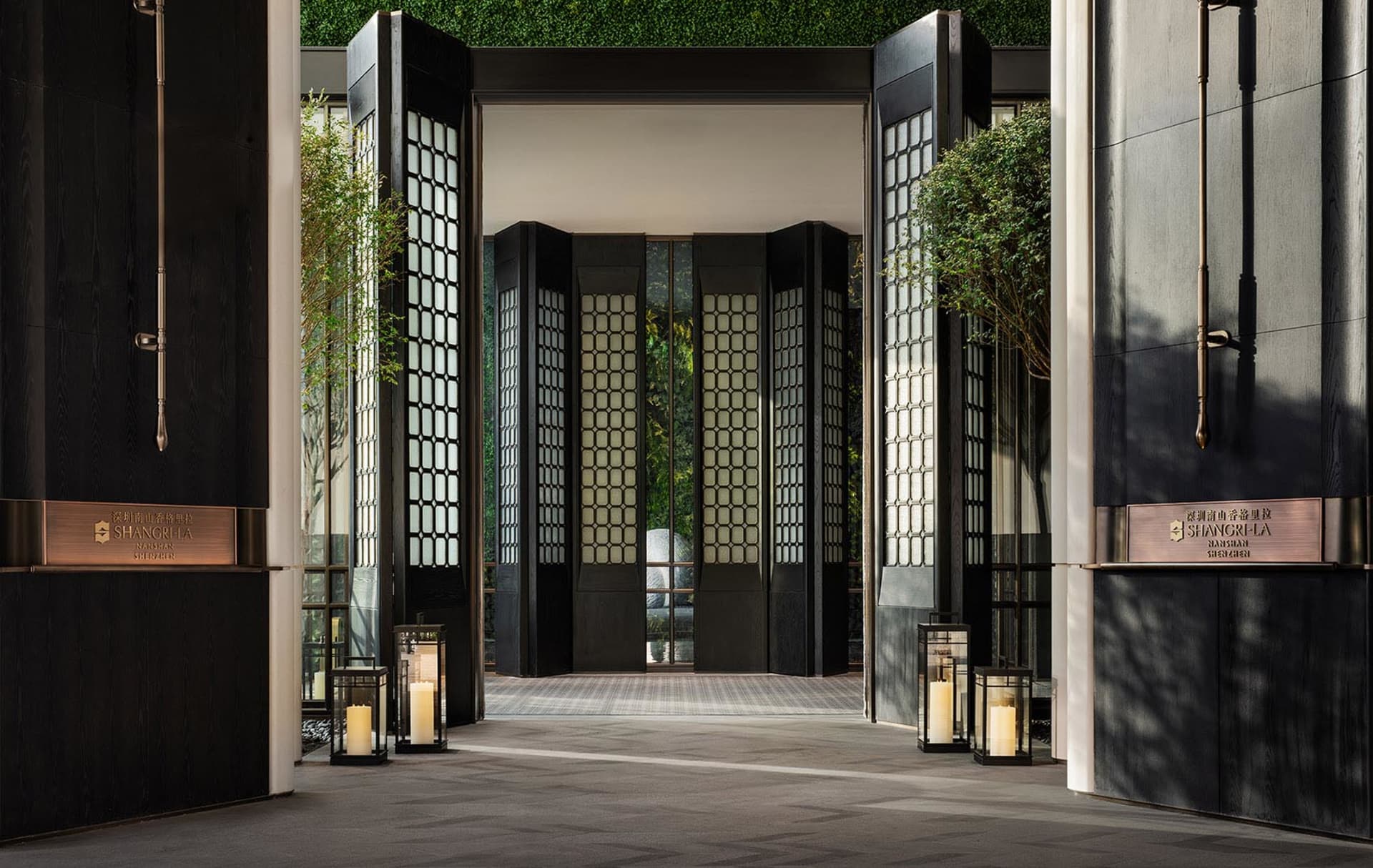 Modern hotel entryway featuring black glass and wooden panels