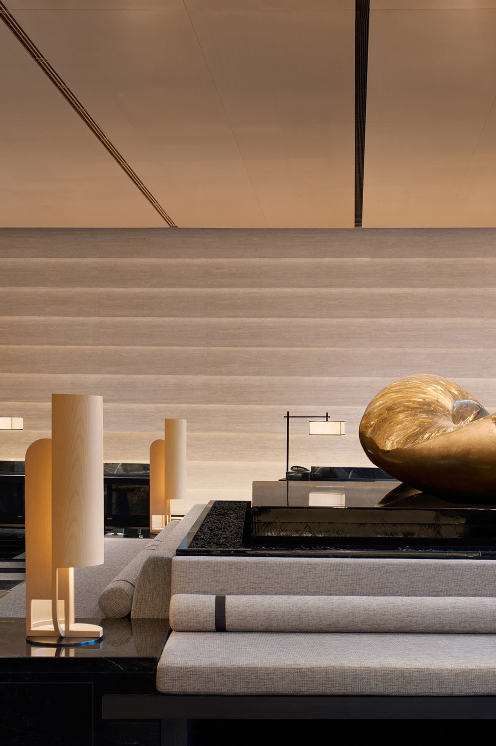 Modern hotel lobby featuring contemporary design with mixed materials including concrete and wood.