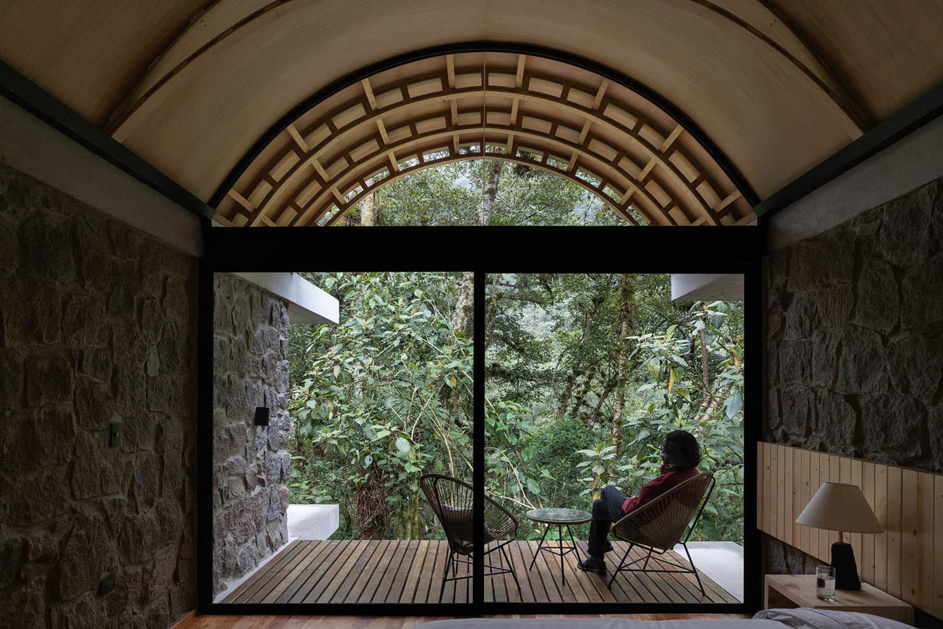 A modern residential interior with a view of the tropical jungle through large windows.