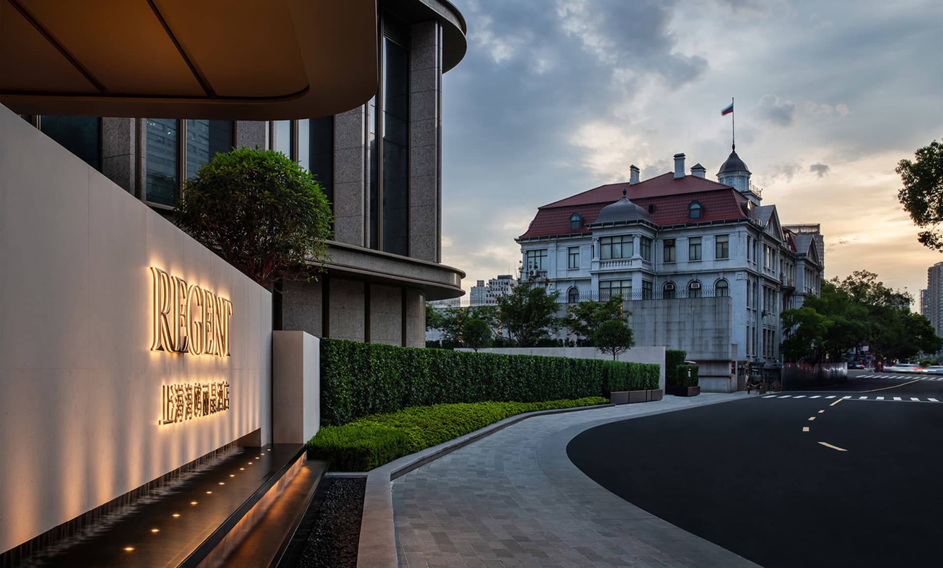 Modern hotel with concrete exterior and lush greenery