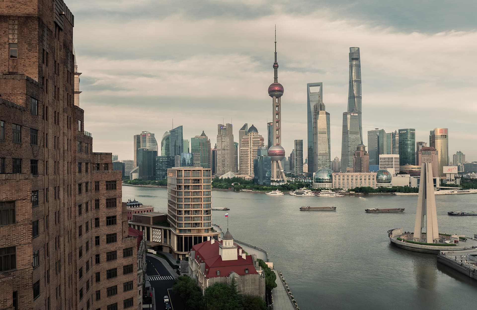 A panoramic view of a modern cityscape featuring contemporary skyscrapers and riverfront architecture.