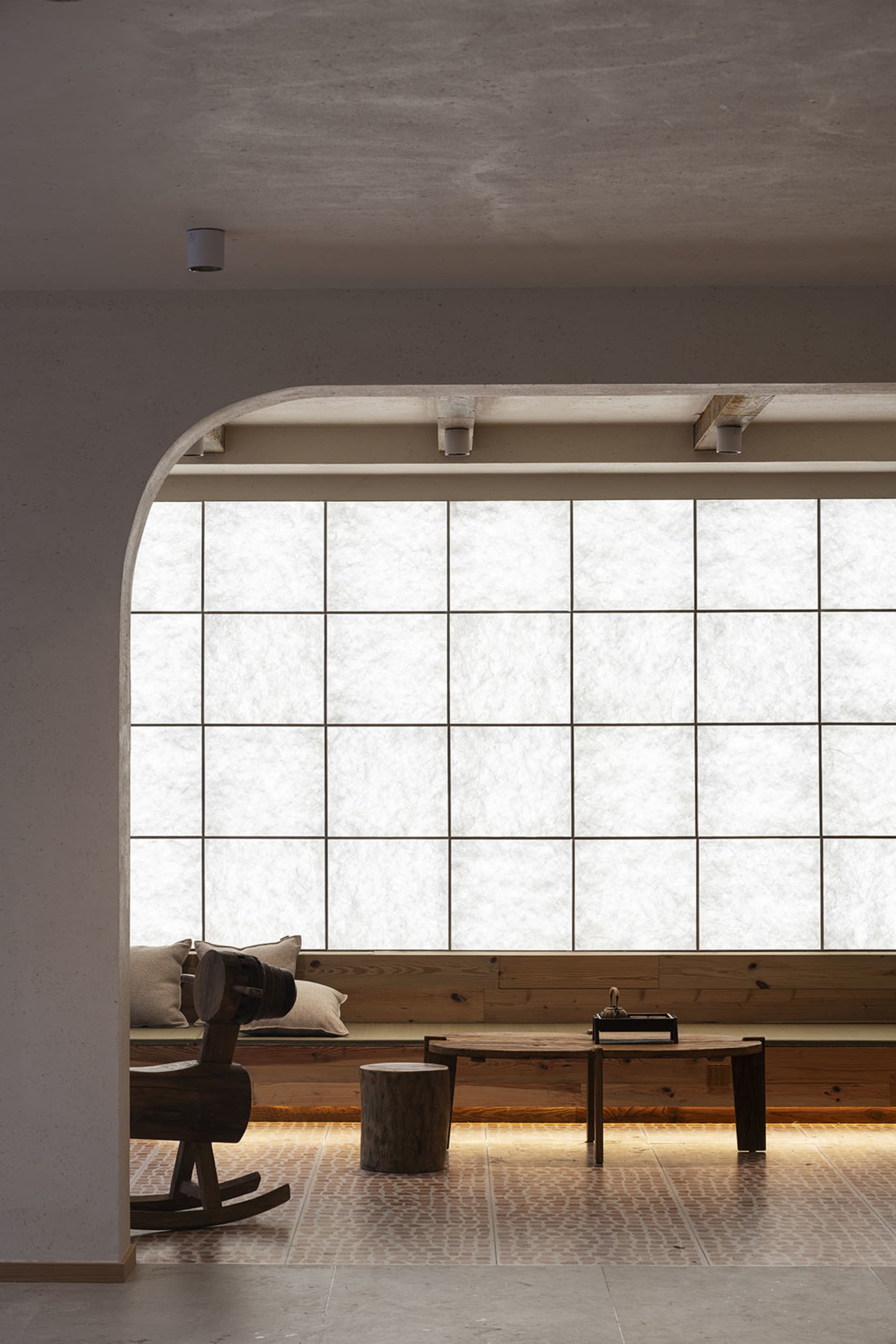 A modern living room with wooden furniture and a large window.