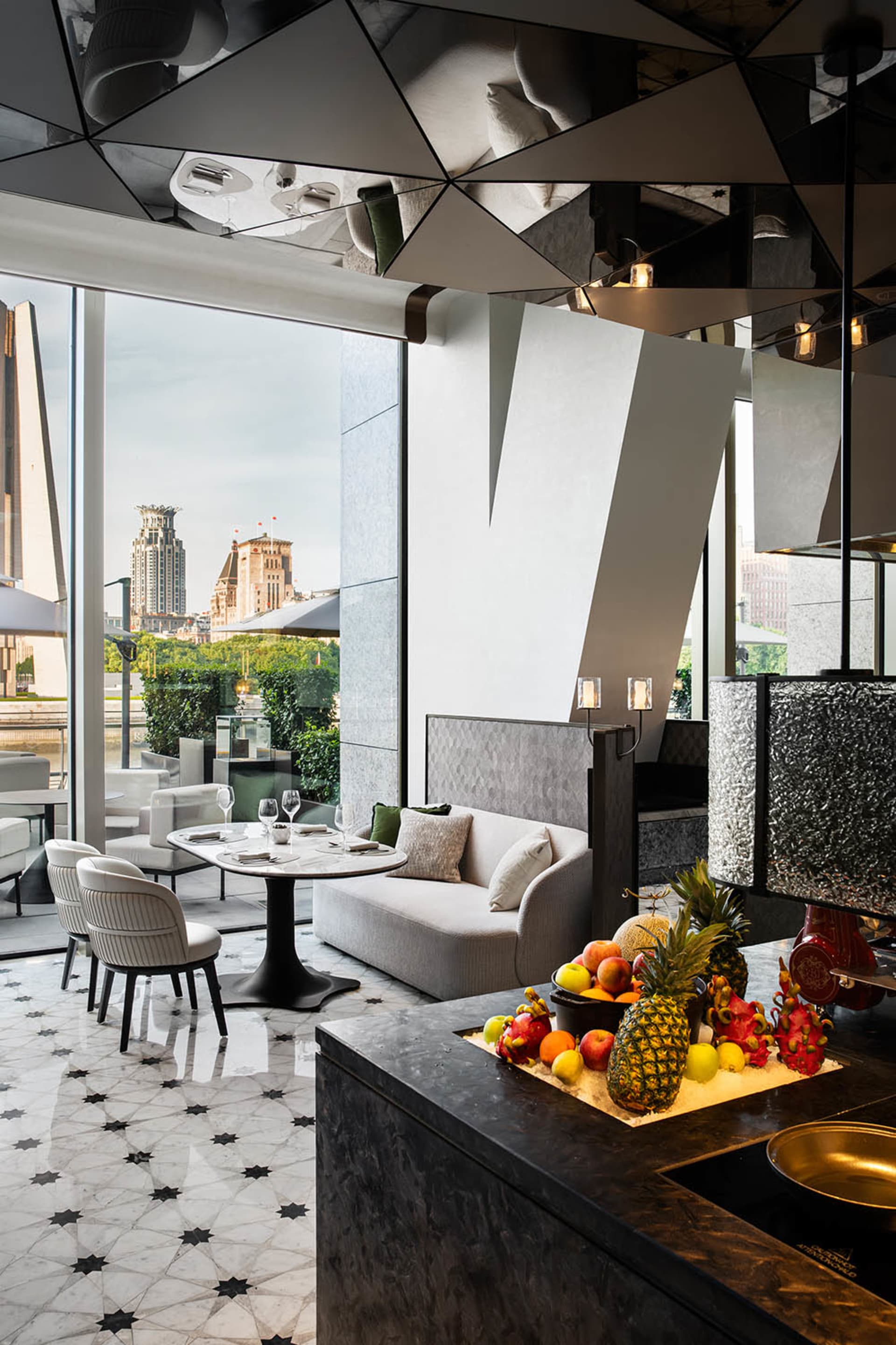 Modern restaurant bar with marble floor, glass walls, and concrete accents