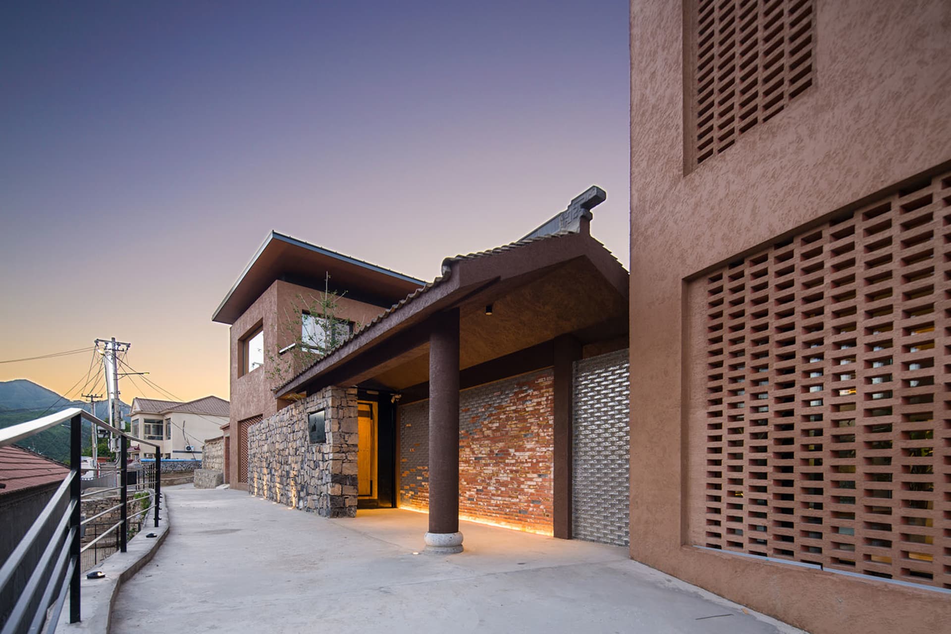 A modern building with a concrete facade and a metal grid window.