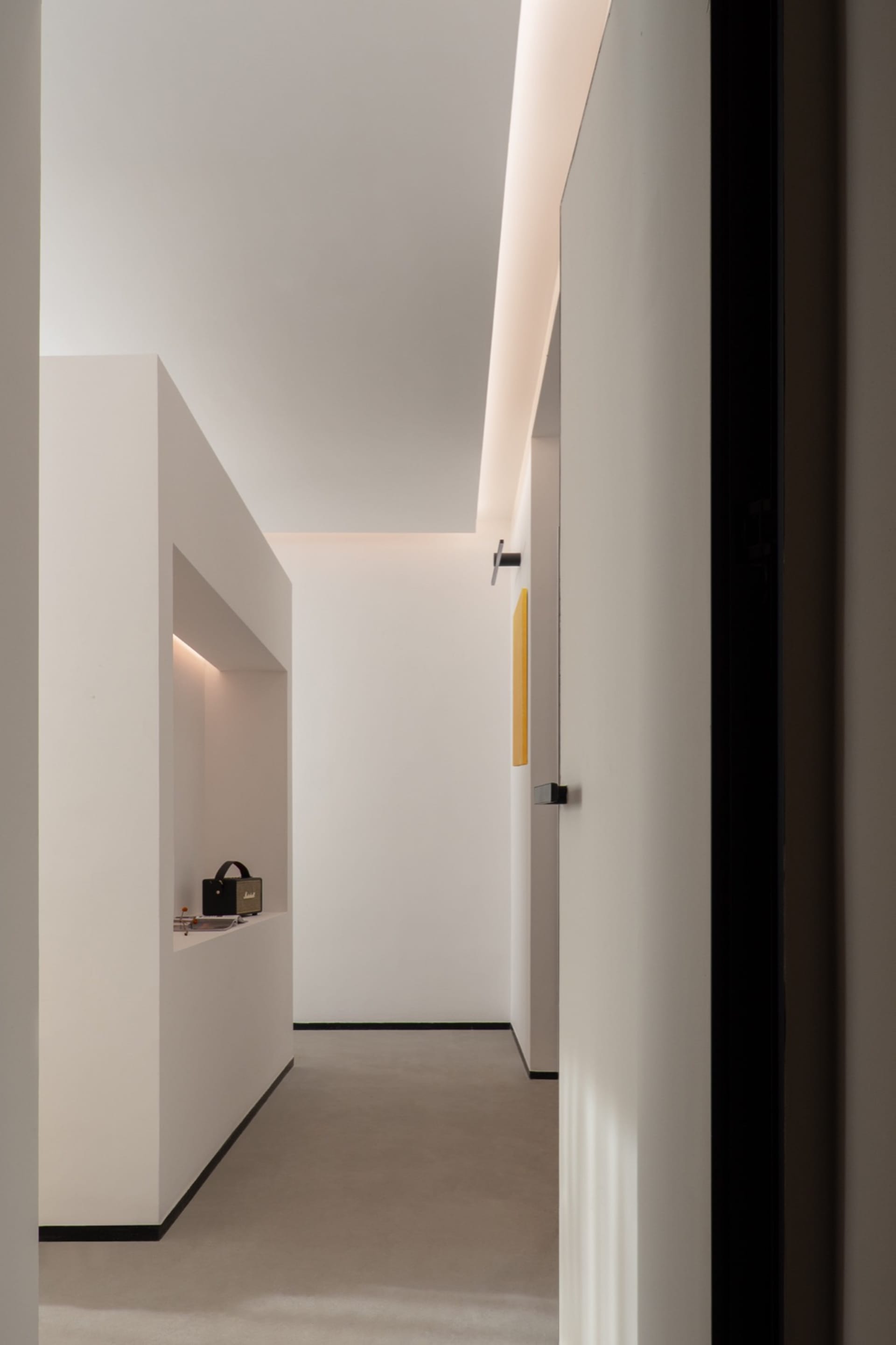 A minimalist white interior with clean lines and a modern design aesthetic, featuring a hallway with a sleek white floor and 