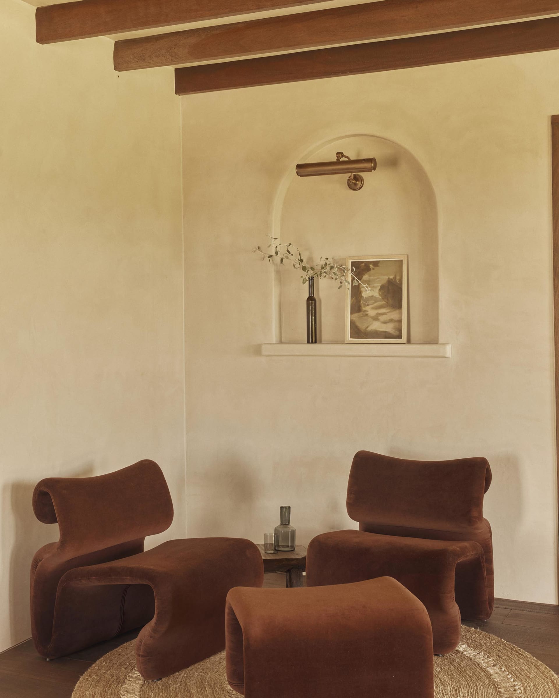 A modern living room featuring comfortable brown velvet couches, a wooden floor, and a warm, inviting ambiance.