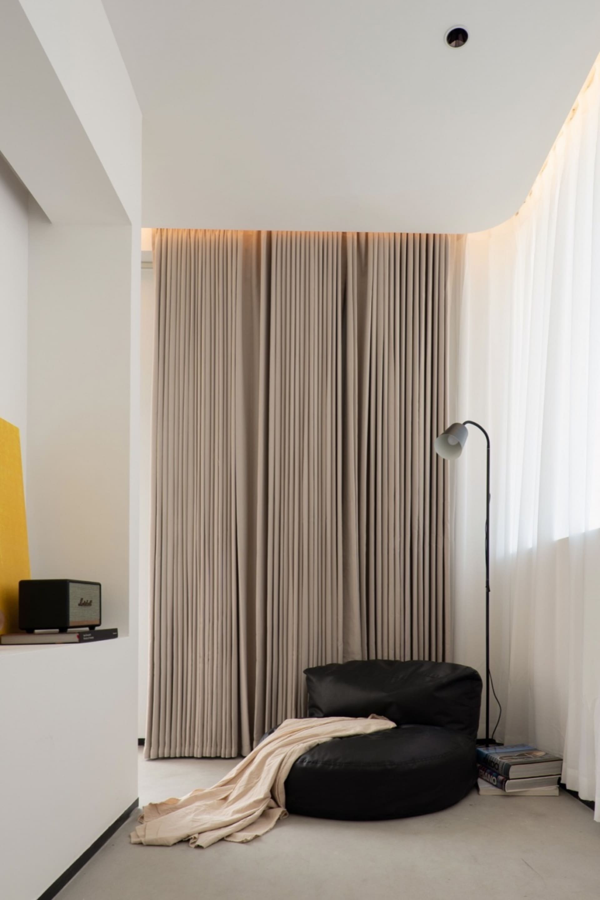 A minimalist living area featuring contemporary furniture, textured fabric, and glass elements.