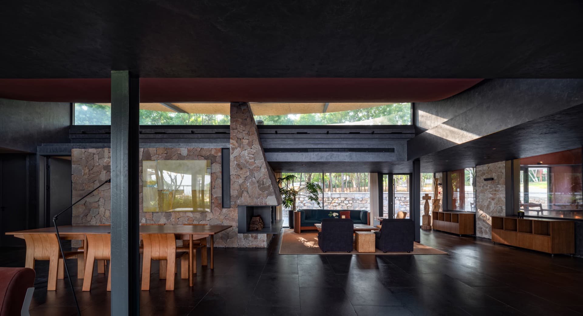 Interior design of a modern living room featuring stone walls and concrete flooring.