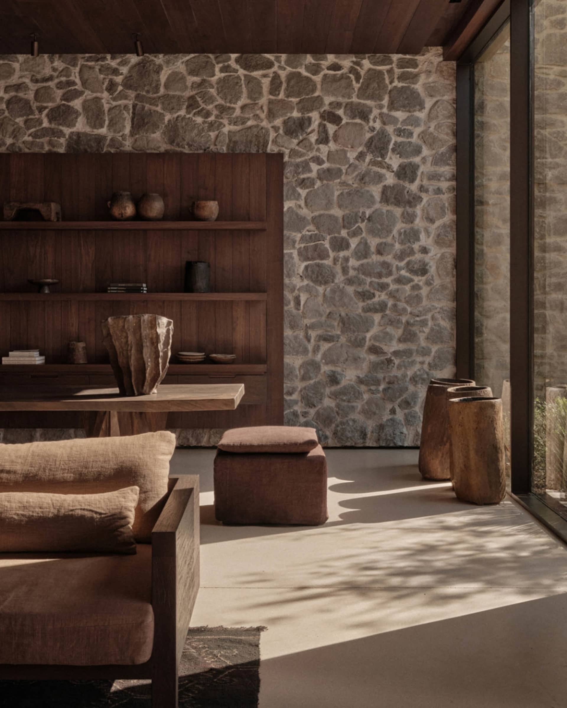 A cozy, rustic industrial living room with stone, concrete, and reclaimed wood elements.