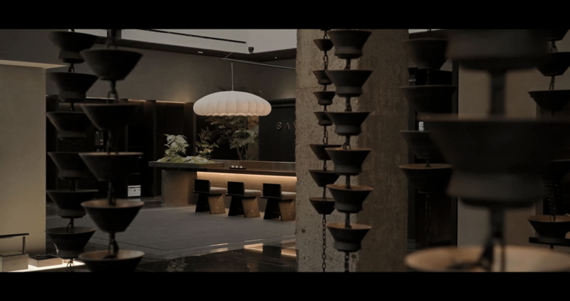 Modern restaurant interior with concrete floors, metal railings, and glass walls