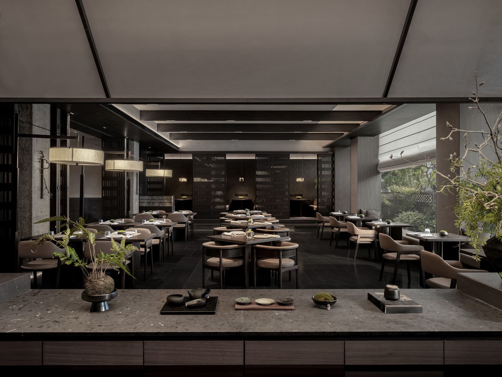 Modern restaurant interior with dark wood furniture, marble countertops, and minimalist design.