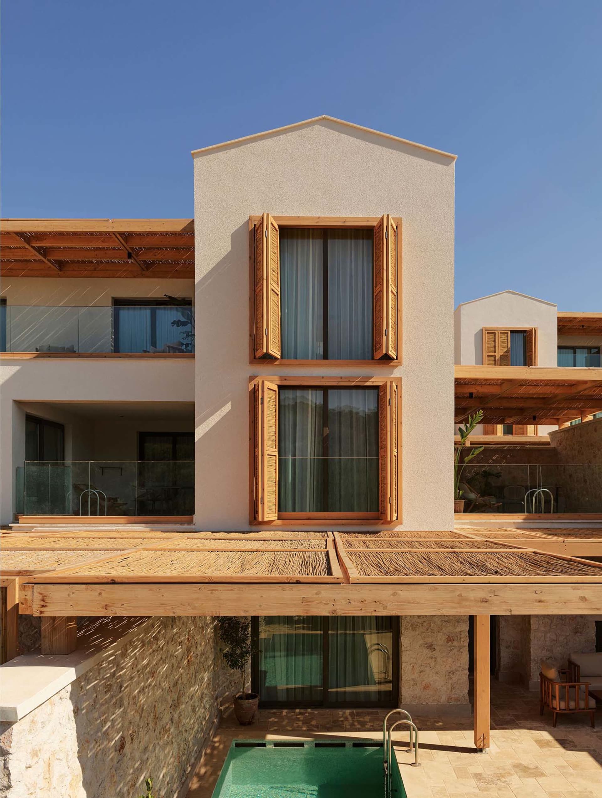 Modern house with wooden accents, stone walls, and large glass windows.