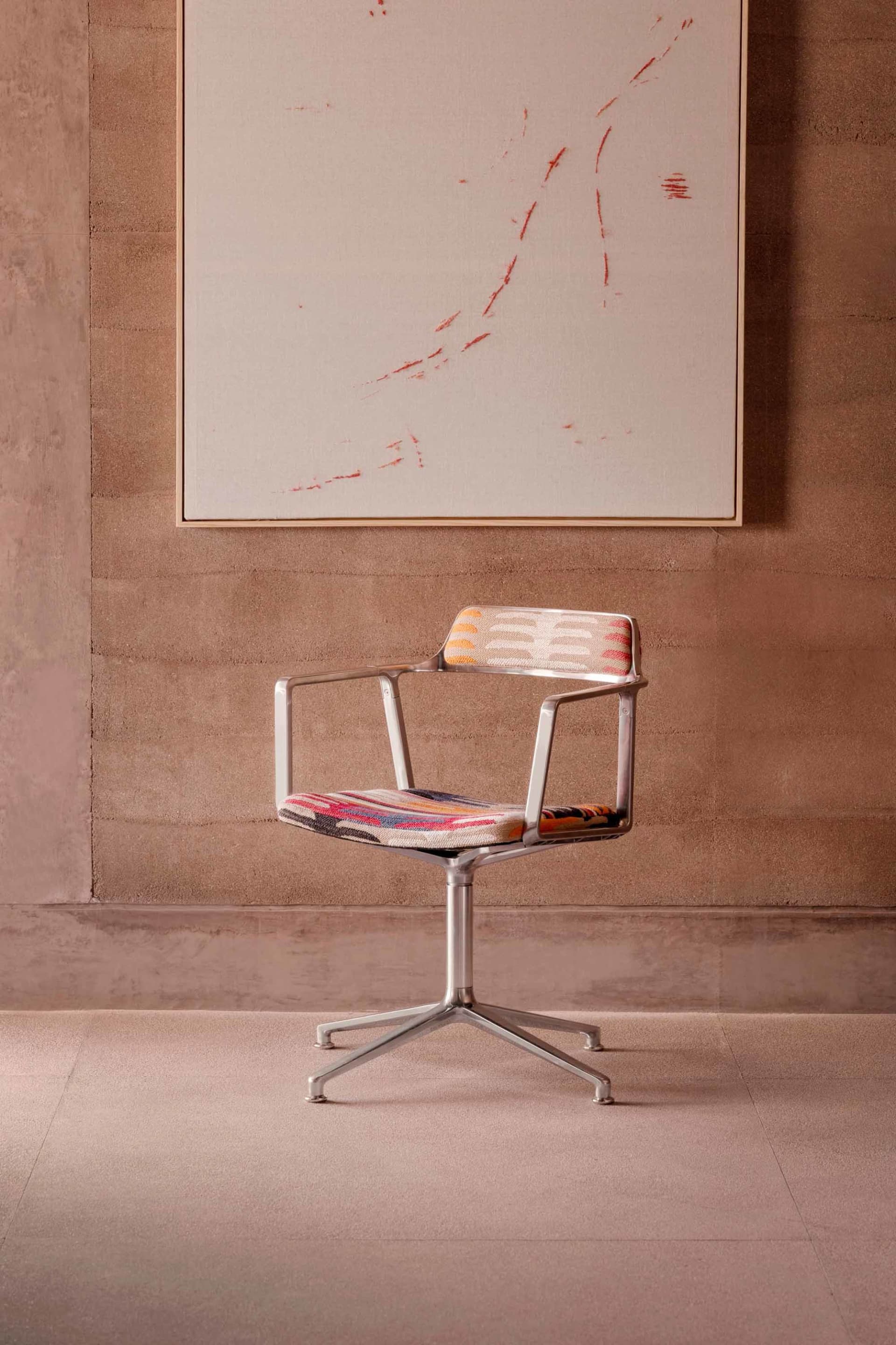 A modern office with a metal-frame chair and upholstered seat and backrest in a business environment.
