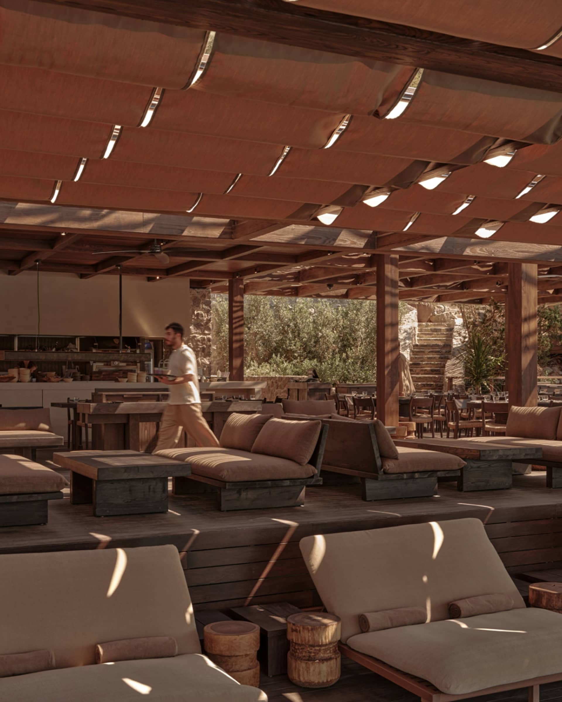Indoor restaurant with rustic décor featuring wooden tables, stone walls, and natural light.