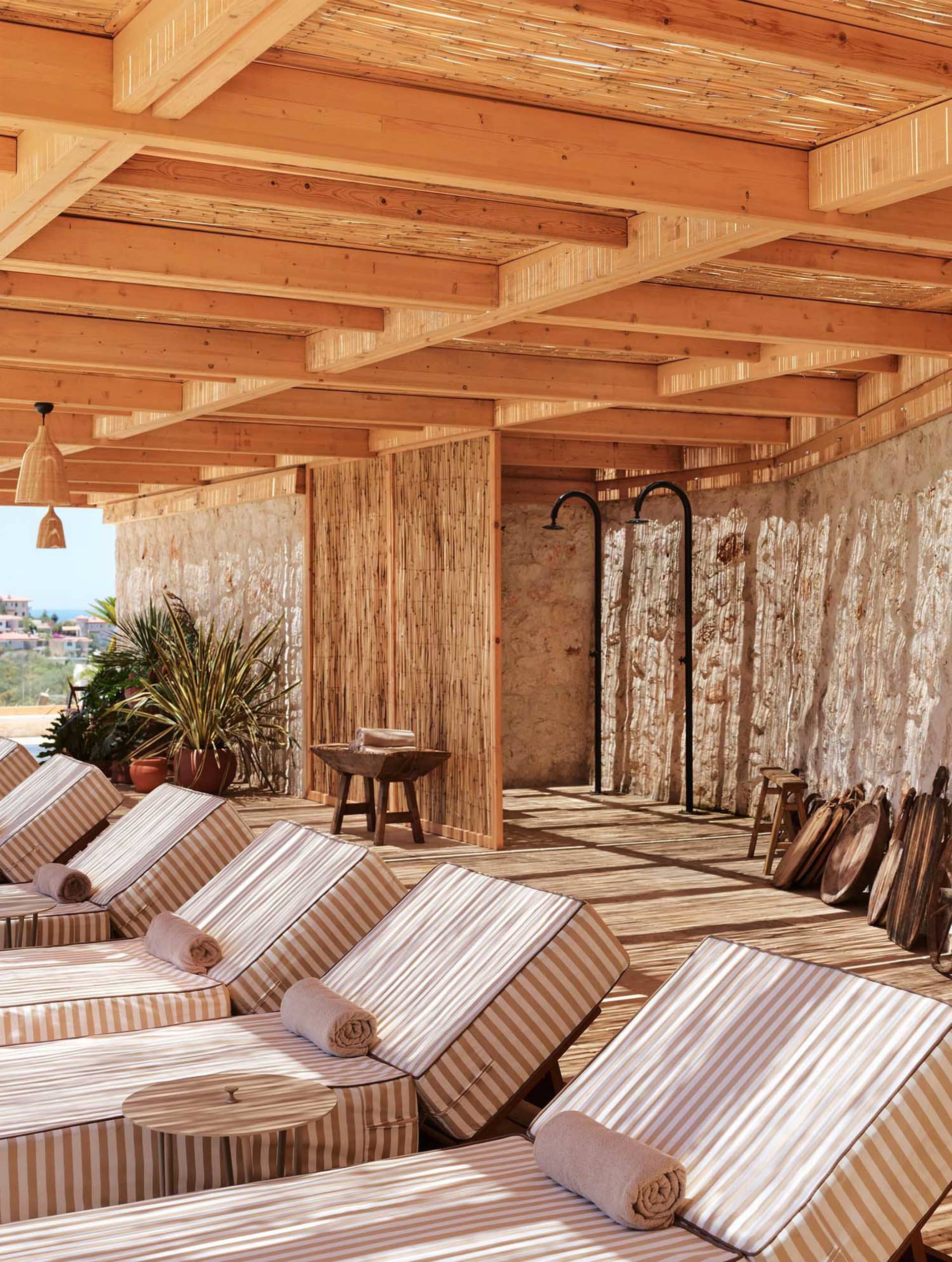 Spa interior with sunbeds, shower, and concrete and wood elements
