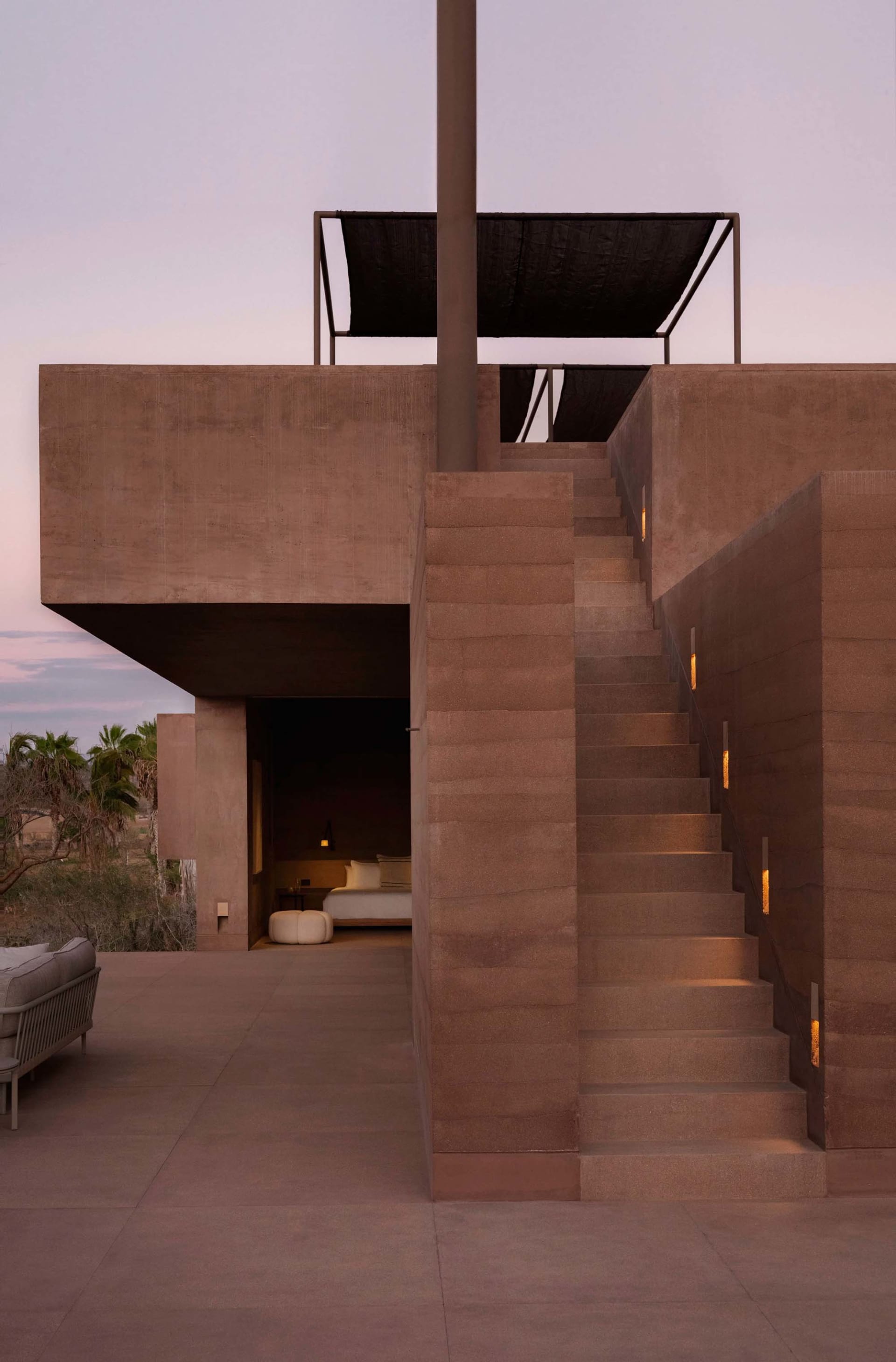 Concrete staircase in a modern residential setting with a black awning.