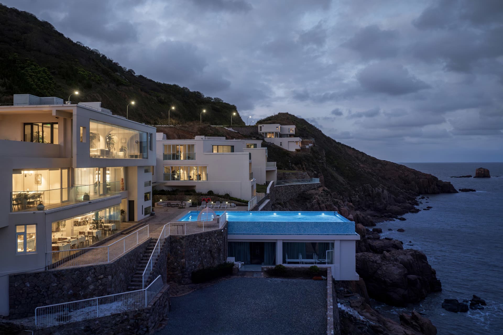 現代住宅建築採用混凝土外牆與大型玻璃窗，眺望海洋景色。