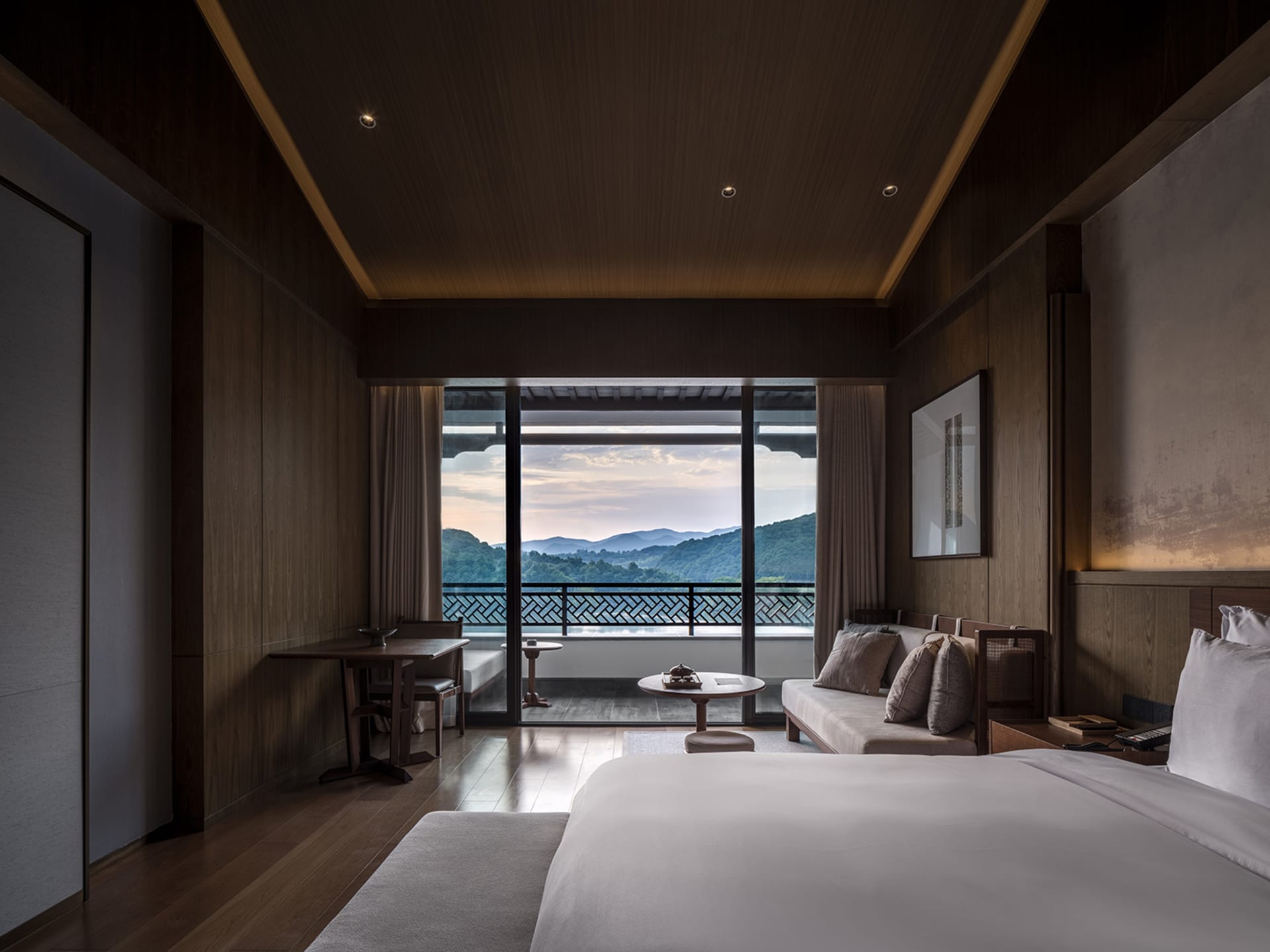 Modern hotel room featuring wooden furniture and a scenic view.