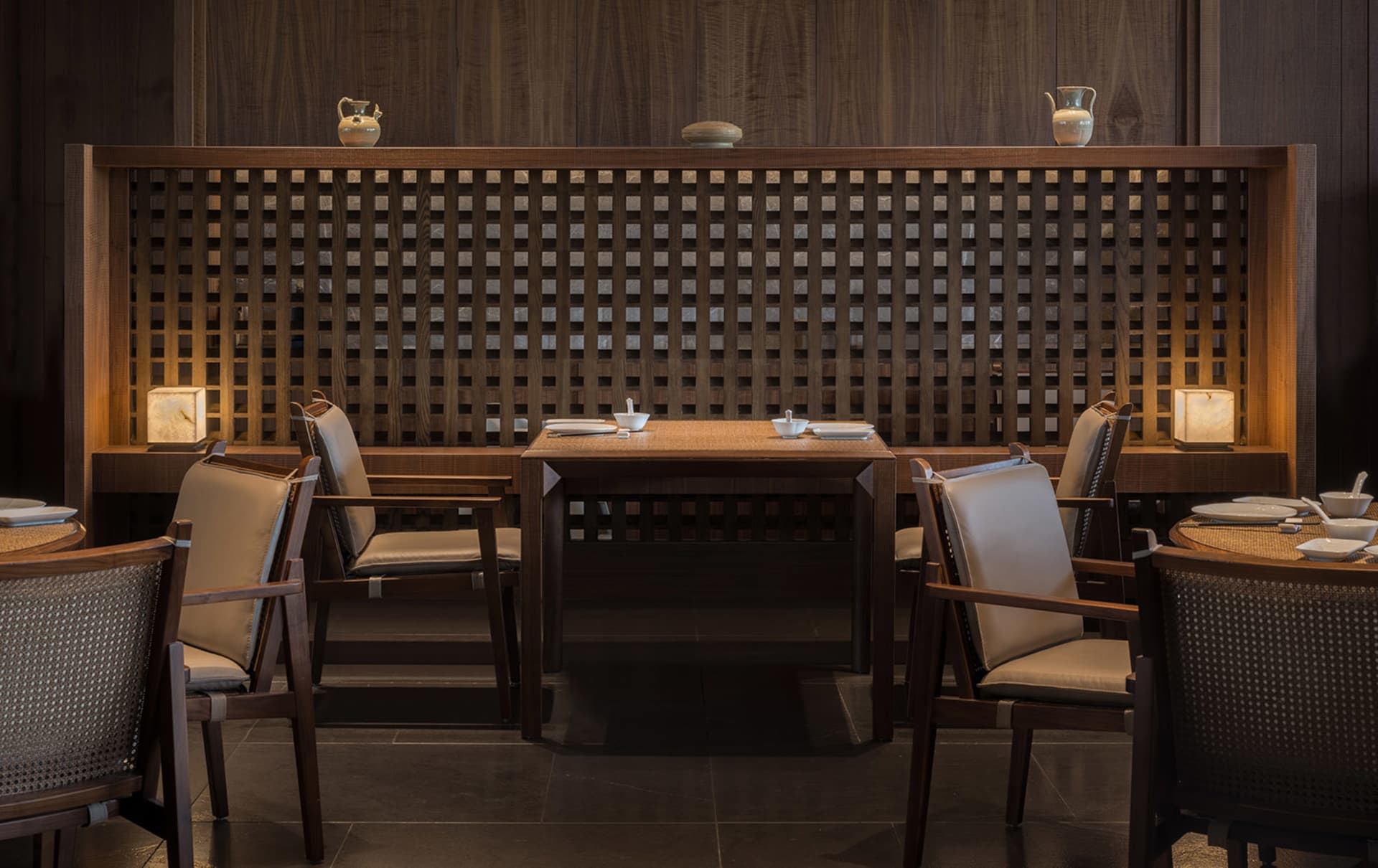 Modern restaurant interior with wooden furniture and lattice partitioning.