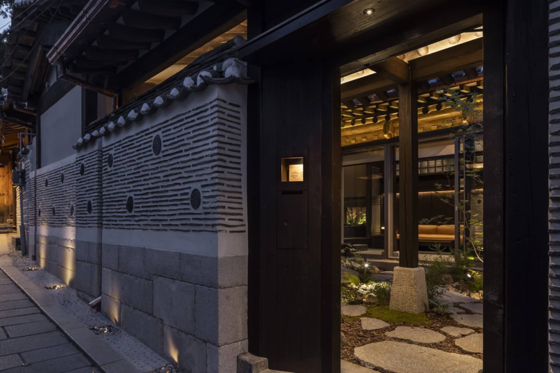 Stone storefront of a retail establishment with wooden accents at dusk.
