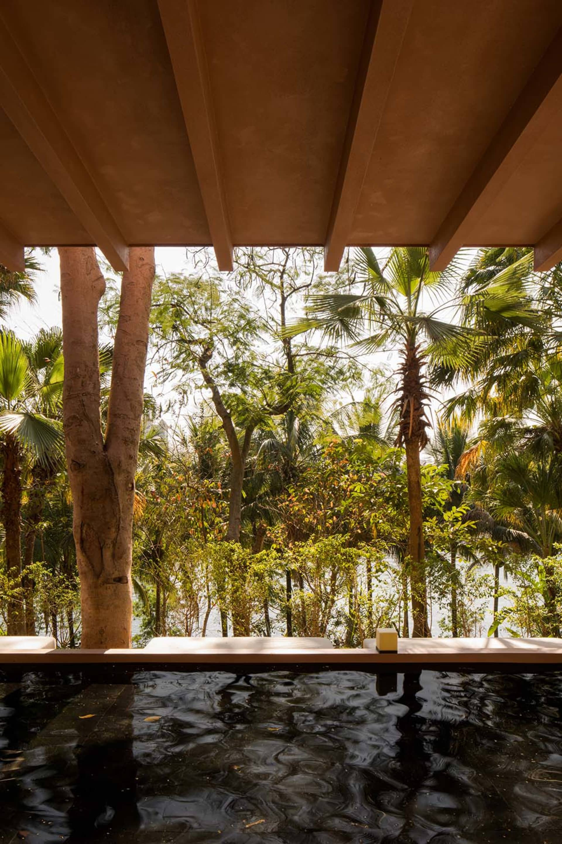 A modern residential area viewed through a sheltered outdoor space, featuring wood, stone, and glass materials.
