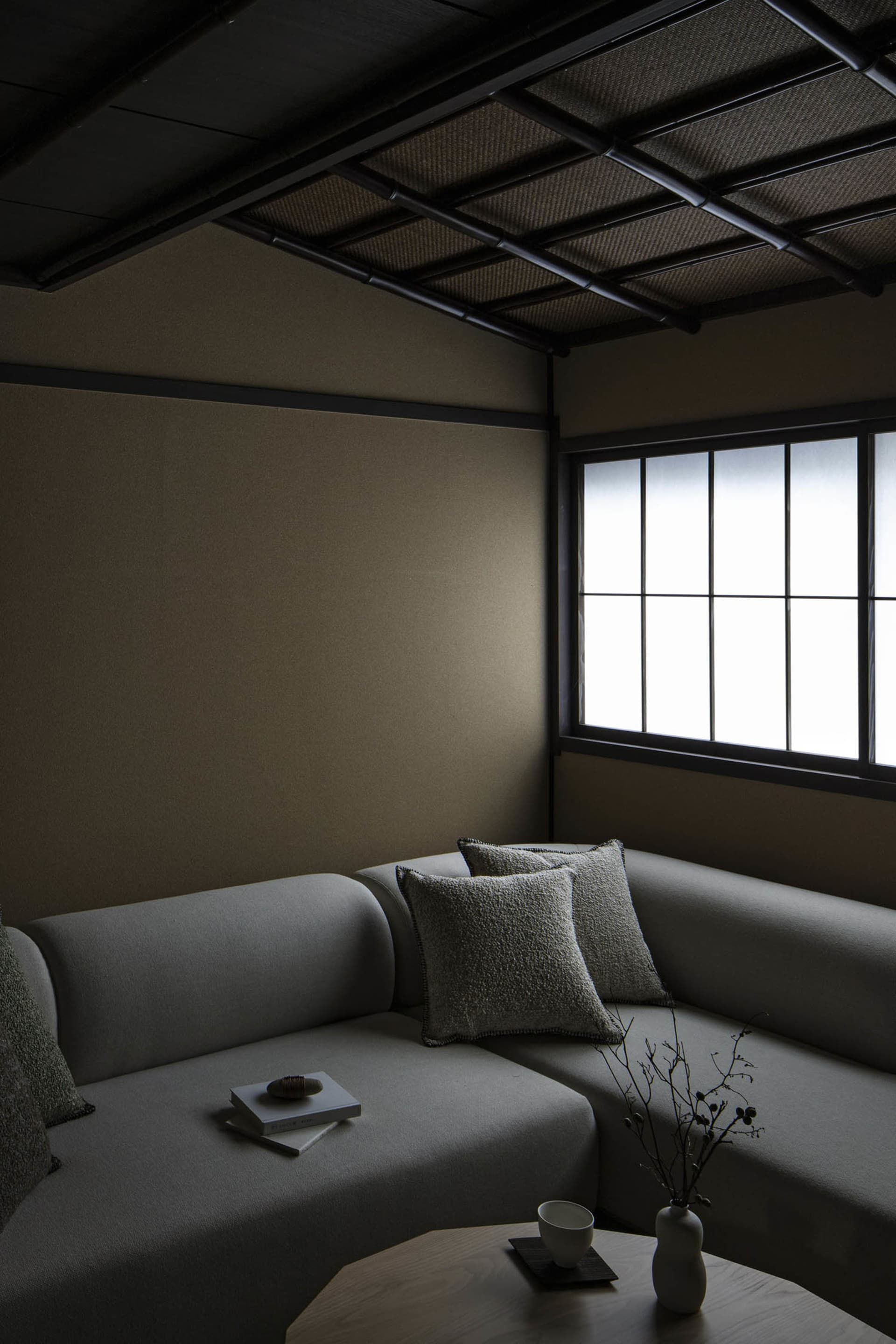 A minimalist living room with grey fabric furniture and wooden accents.