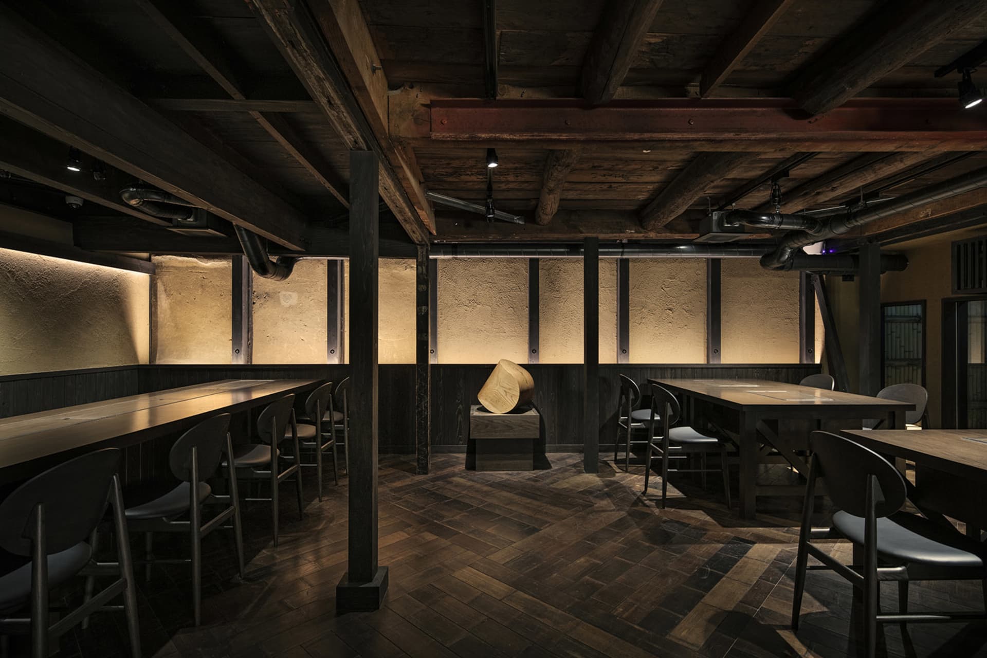 工業風餐廳內有木製餐桌椅、裸露木樑，以及溫暖燈光。