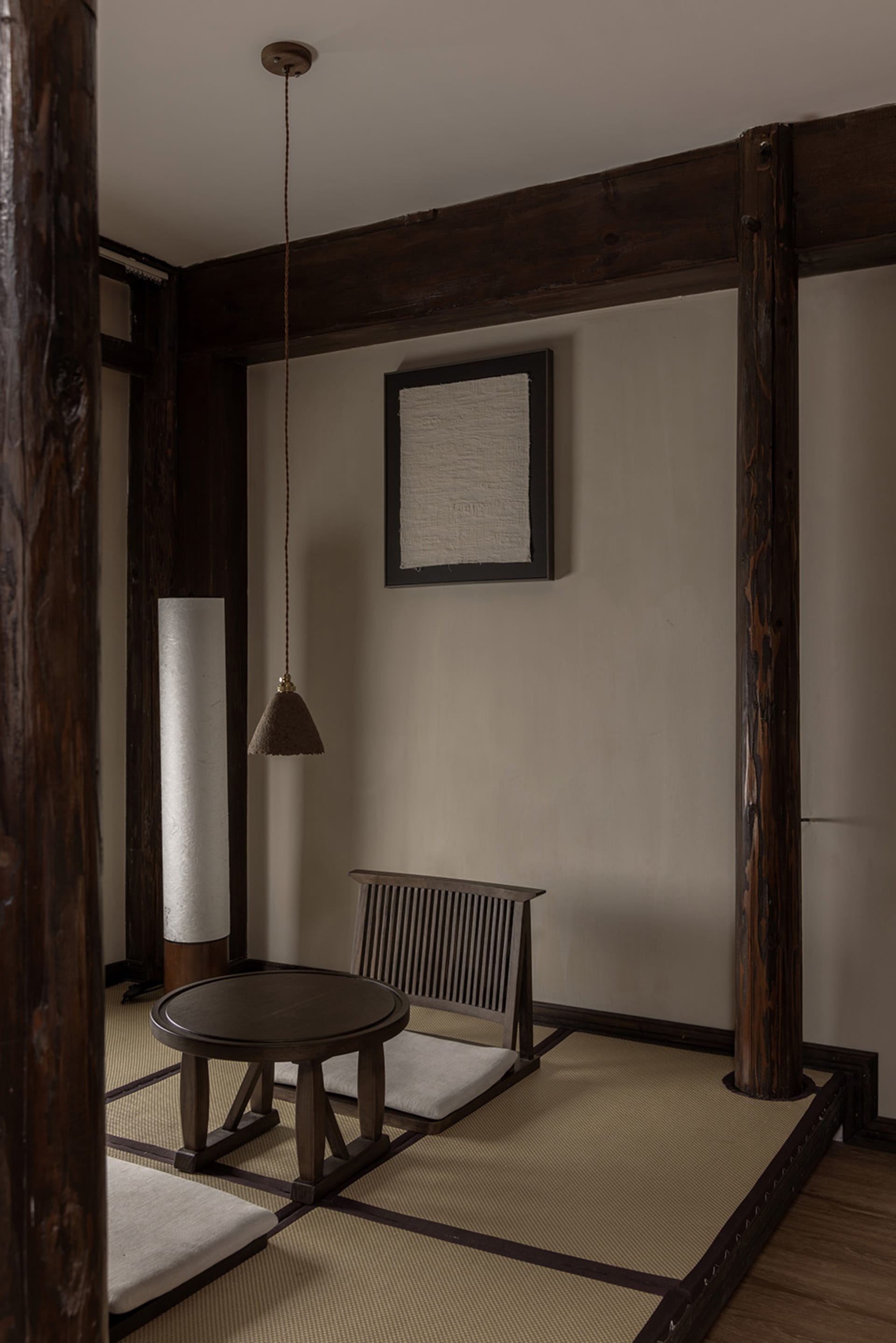 A minimalist living room featuring tatami mats and wooden furniture.