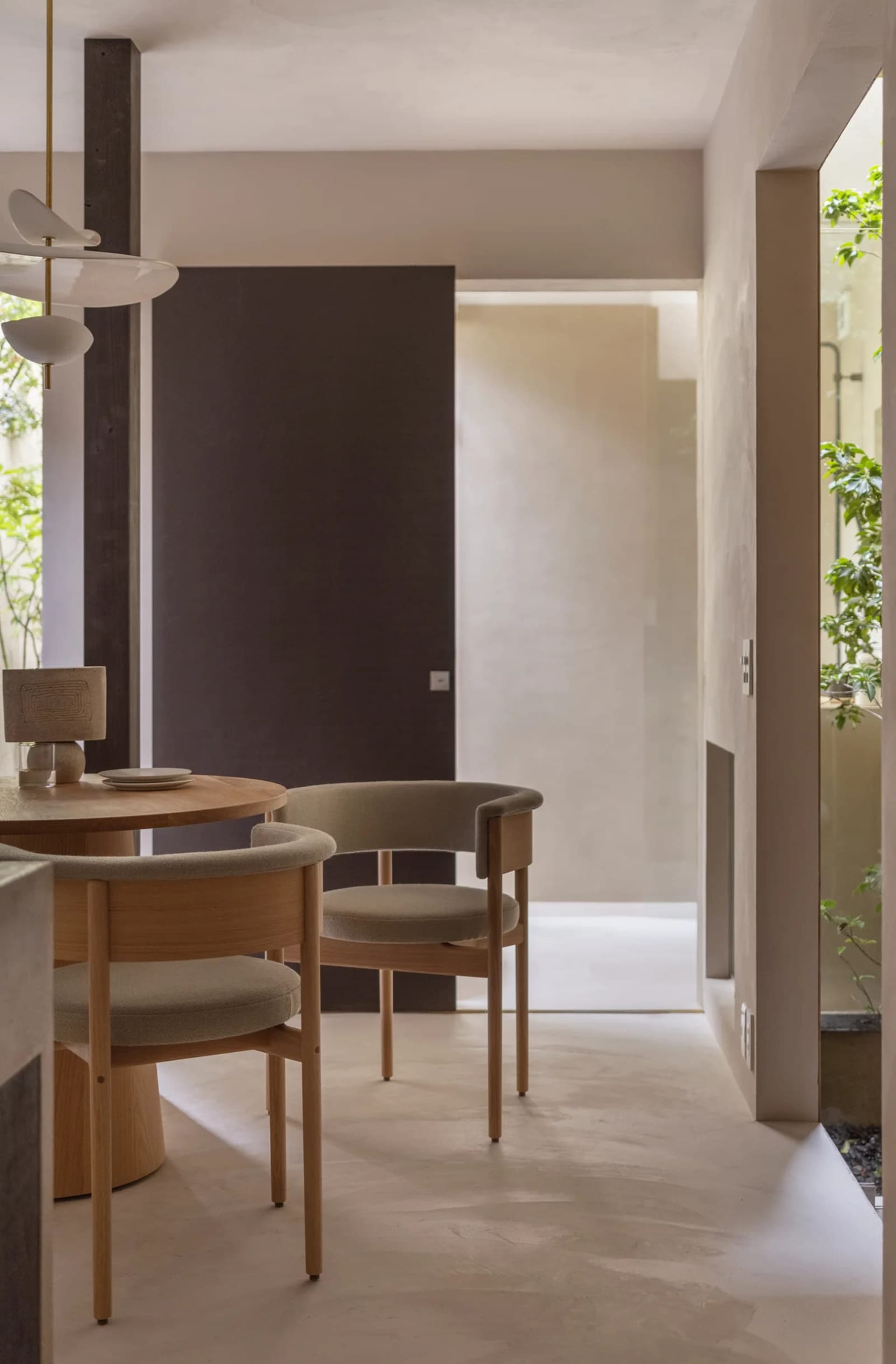 Modern dining room featuring concrete flooring and minimalist chairs.