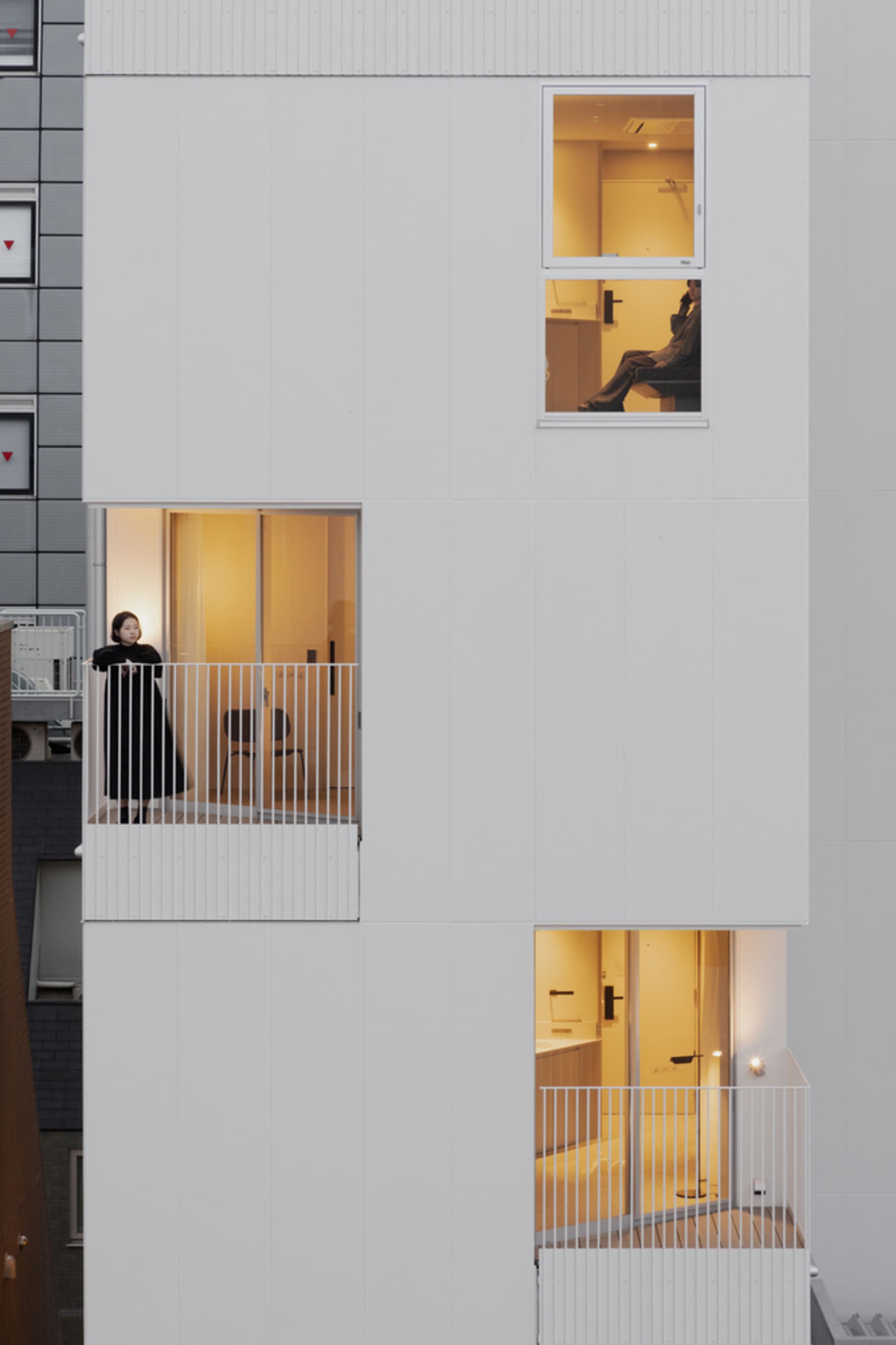 A rendering of a modern apartment building with white exterior walls.