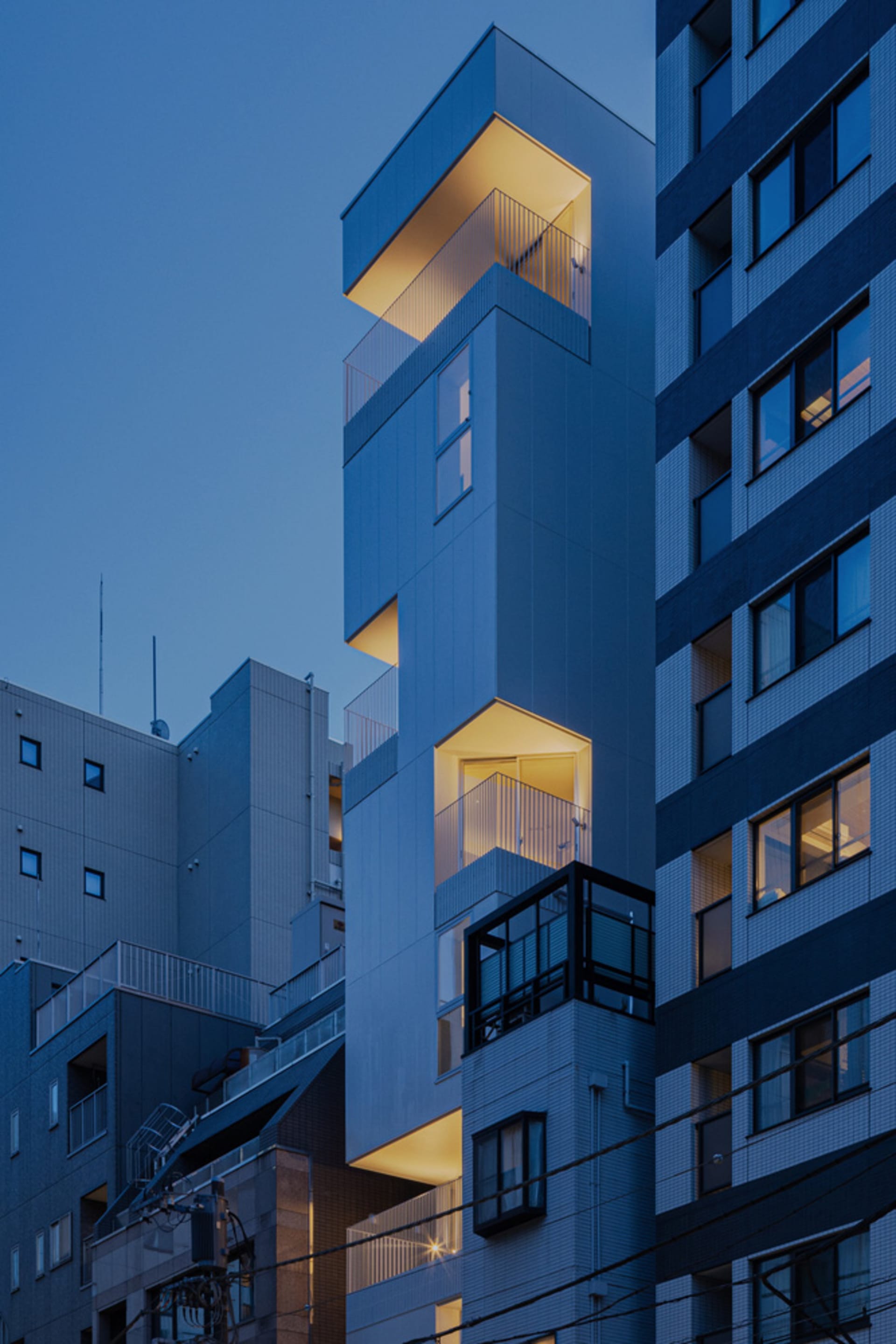 黃昏時分,藍色瓷磚外牆的建築被燈光照亮