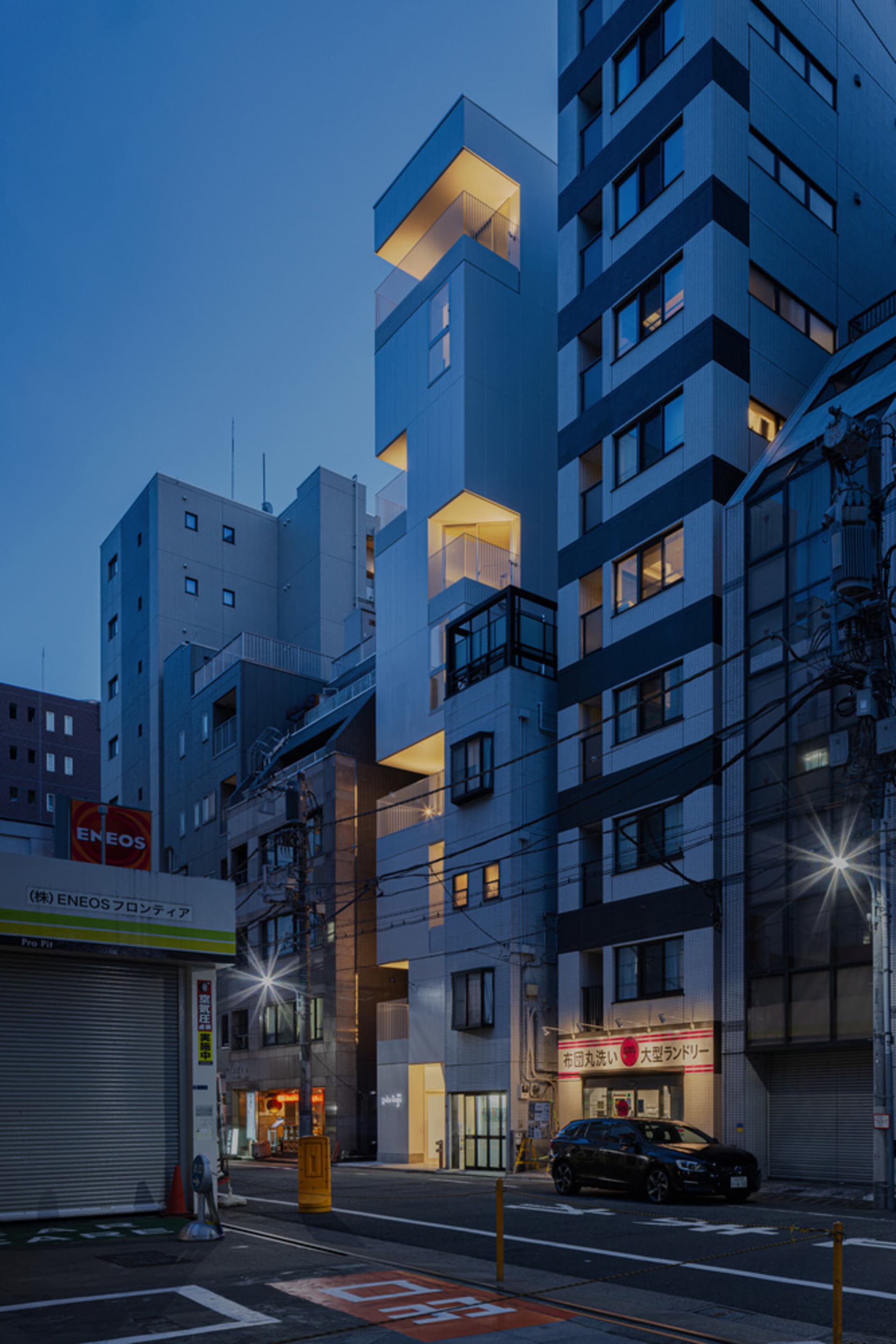 一座現代建築採用金屬鋁板包覆,具有獨特的角狀設計與發光的陽台。