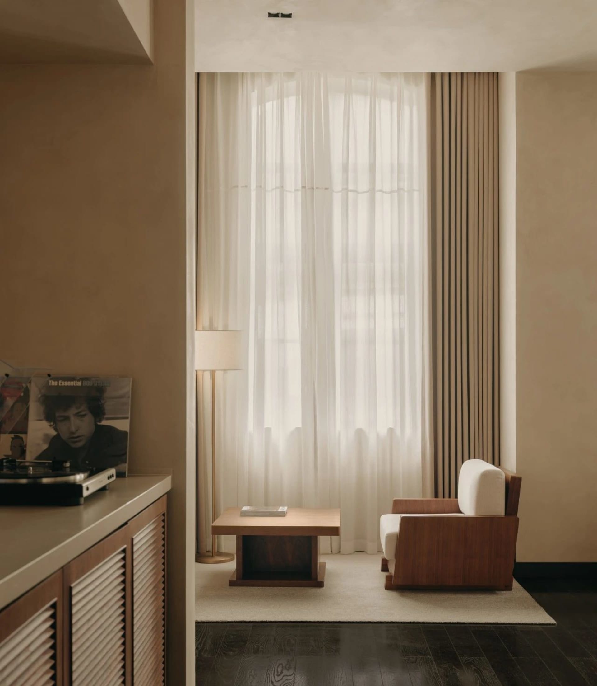 A modern living room featuring neutral-colored furniture and decor.