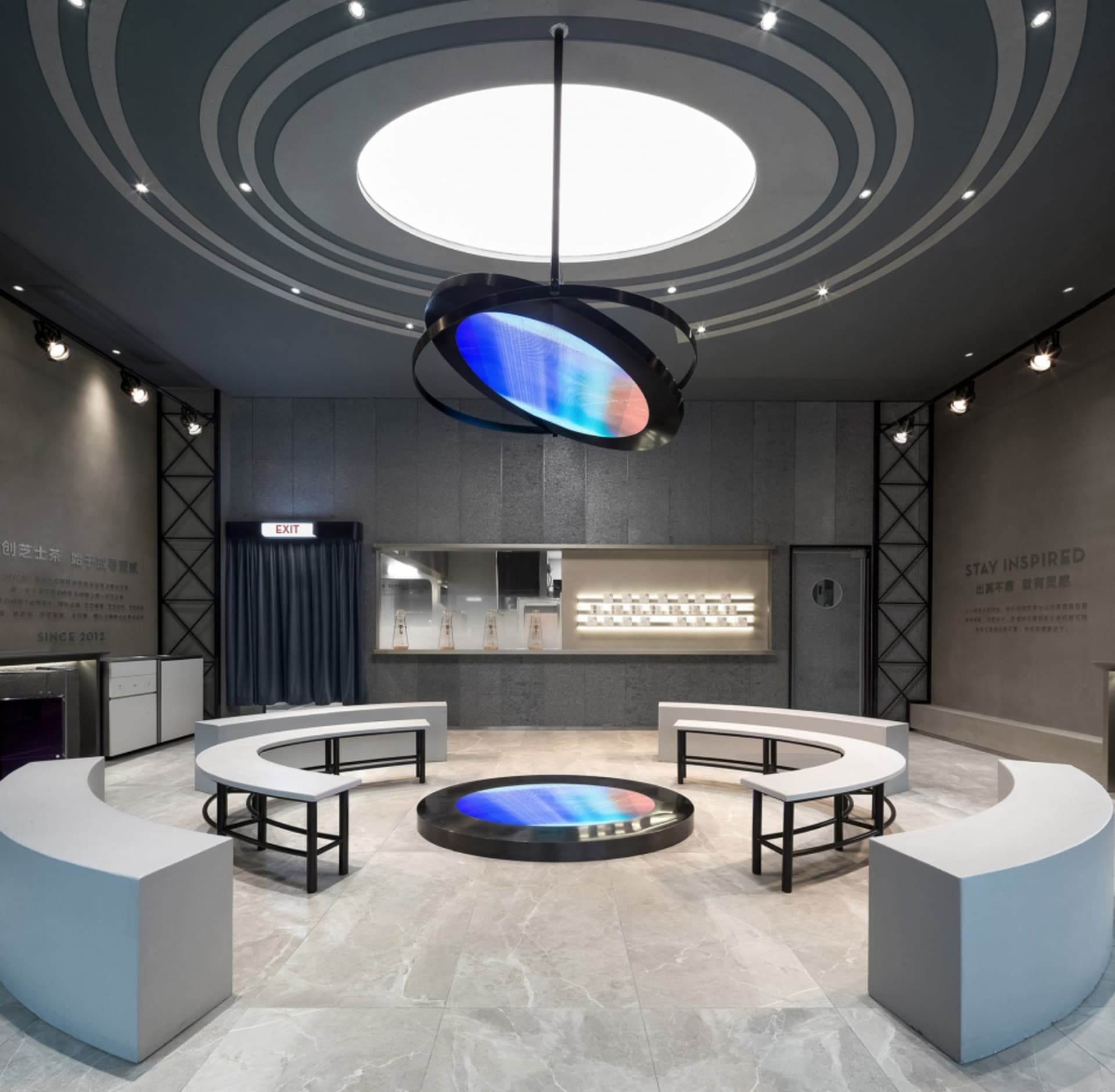 室內展覽廳呈現工業設計元素，包含混凝土牆面、玻璃展示櫃與LED燈光。