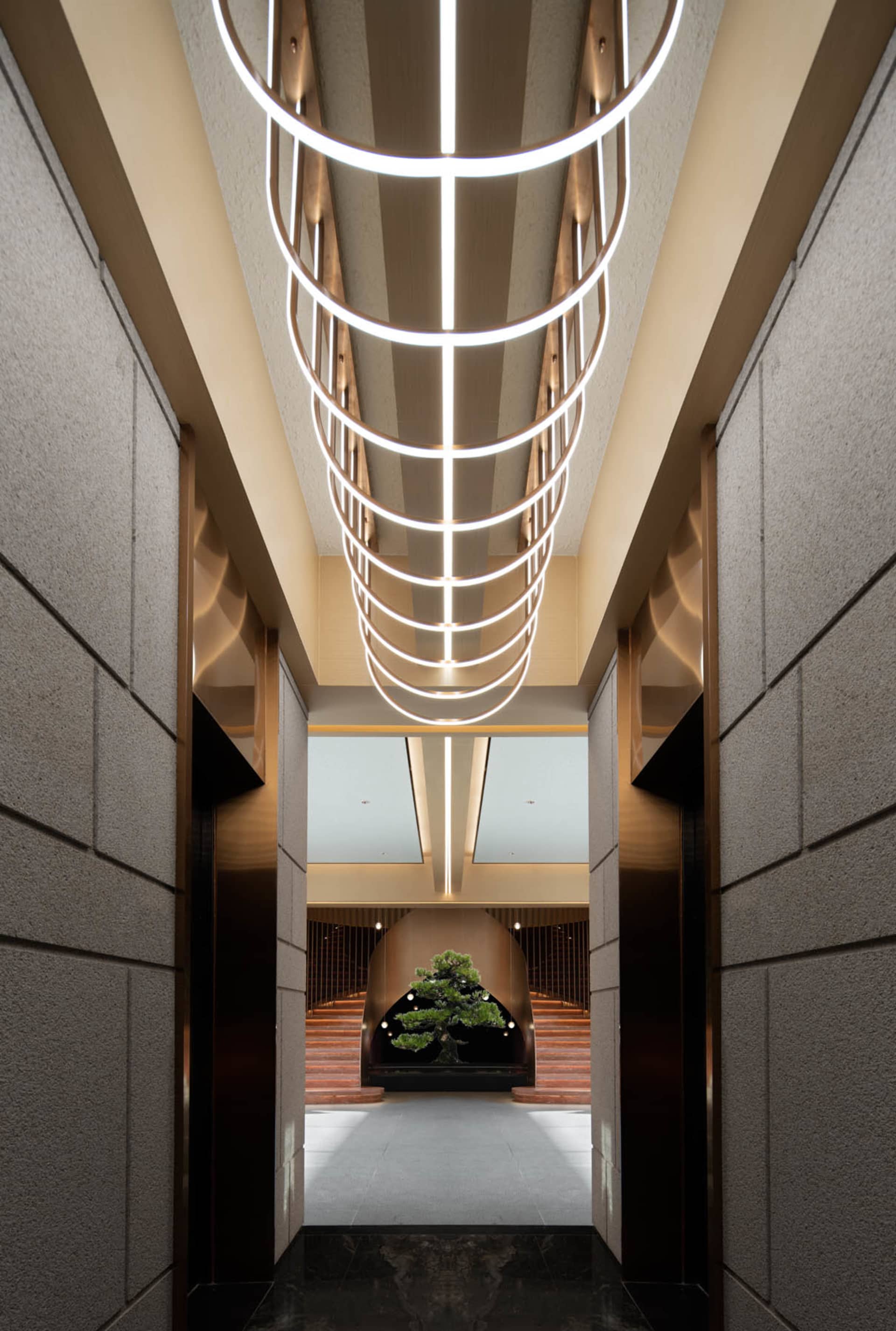 A modern lounge area featuring metal elements and geometric lighting fixtures.
