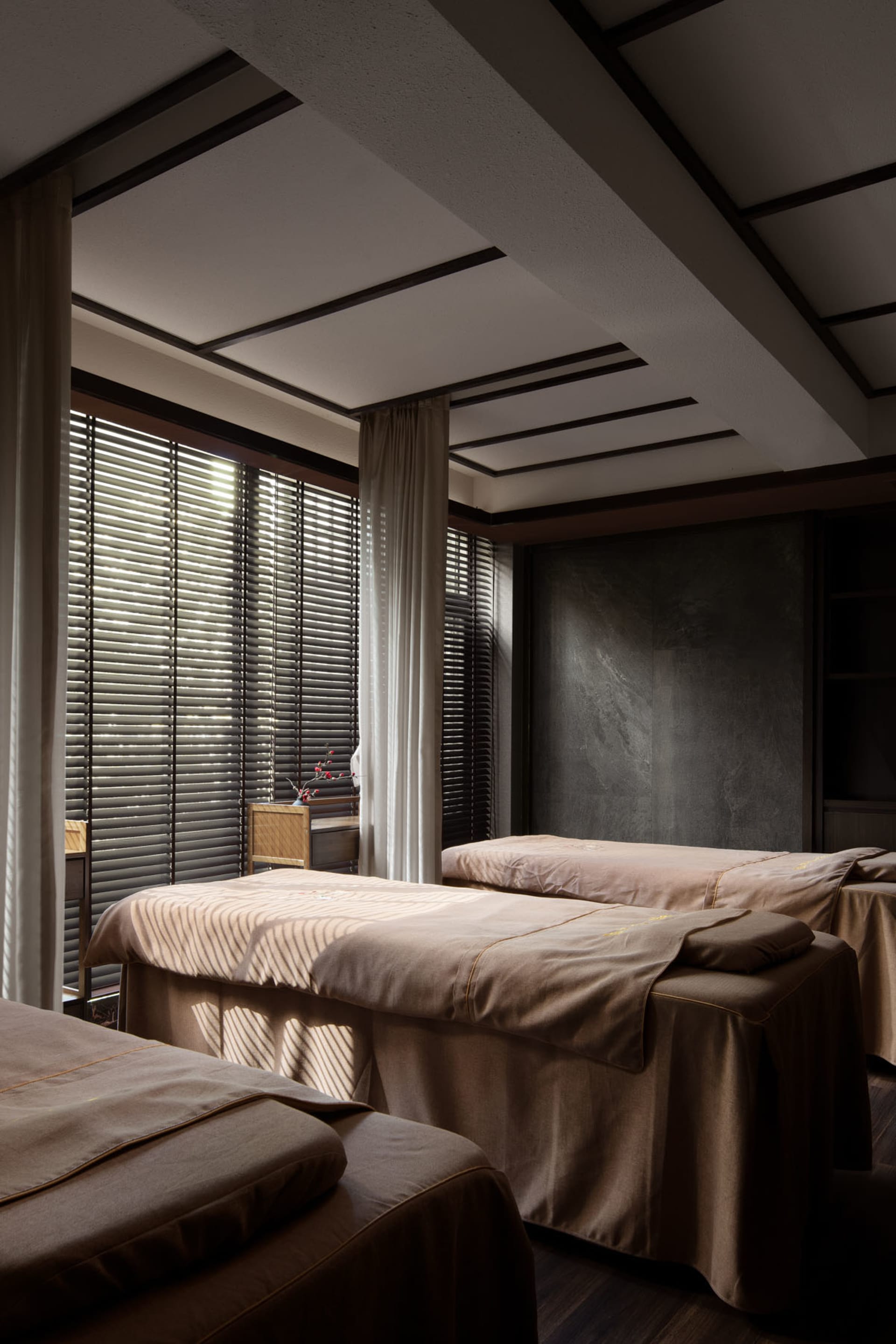Spa interior featuring three massage beds covered in fabric.