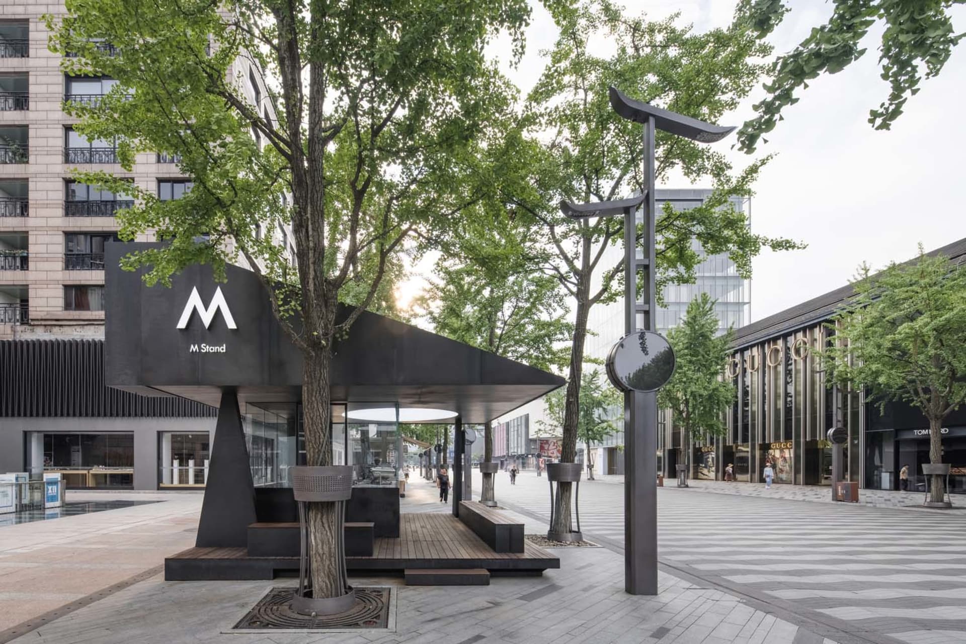 Modern urban architecture featuring metal, glass, concrete, and greenery