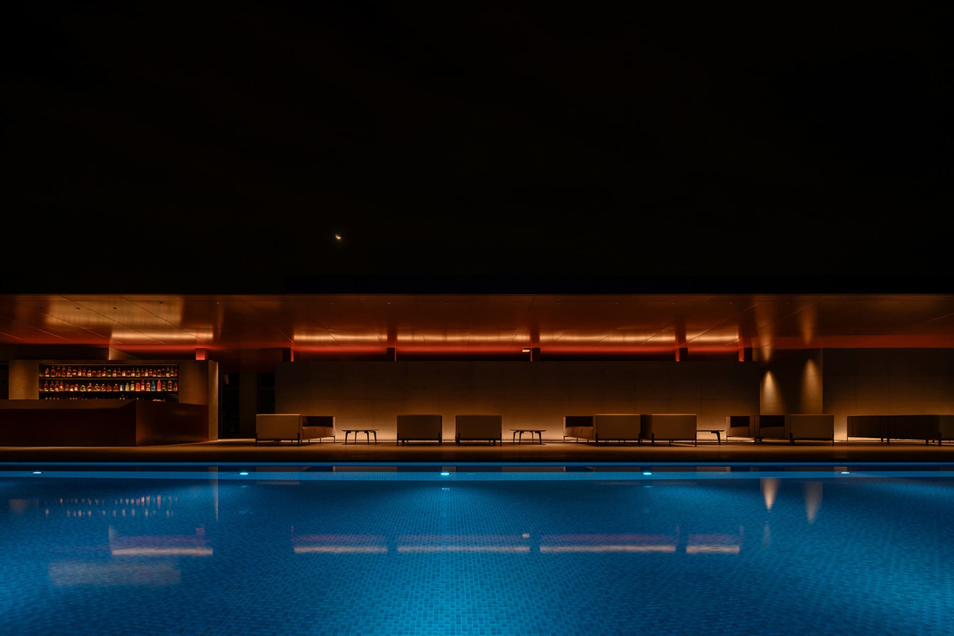 現代工作室擁有玻璃牆與游泳池，夜景呈現。