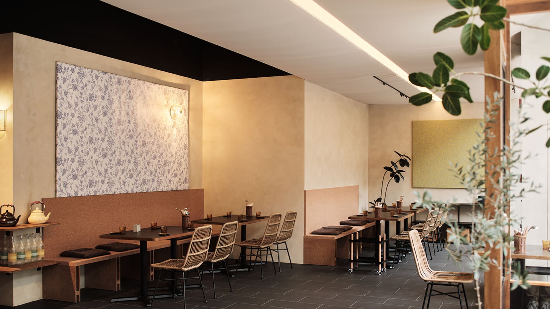 Modern cafe interior featuring wooden tables, metal chairs, and contemporary design elements.