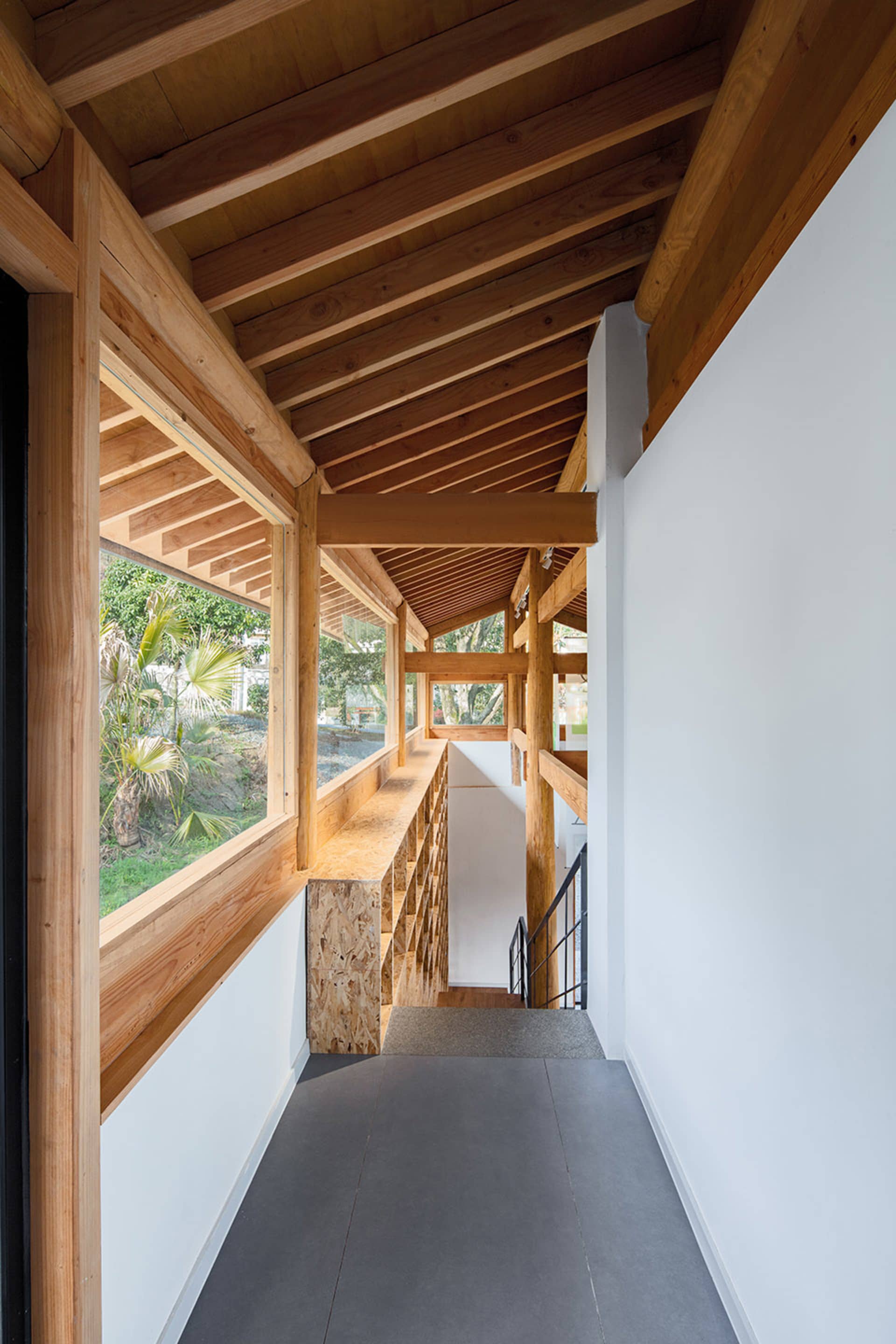 現代住宅室內，展示木質橫樑與混凝土地板。